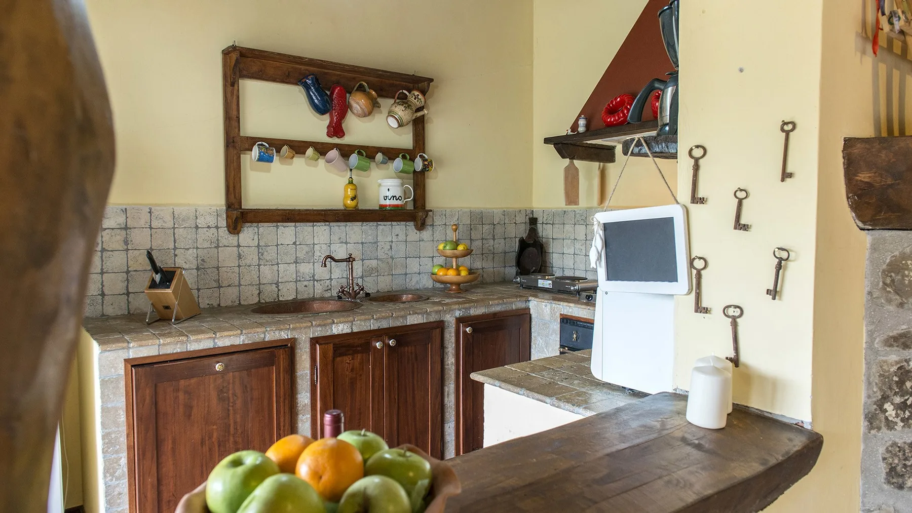 A rustic kitchen with wooden cabinets, a tiled backsplash, and a countertop.