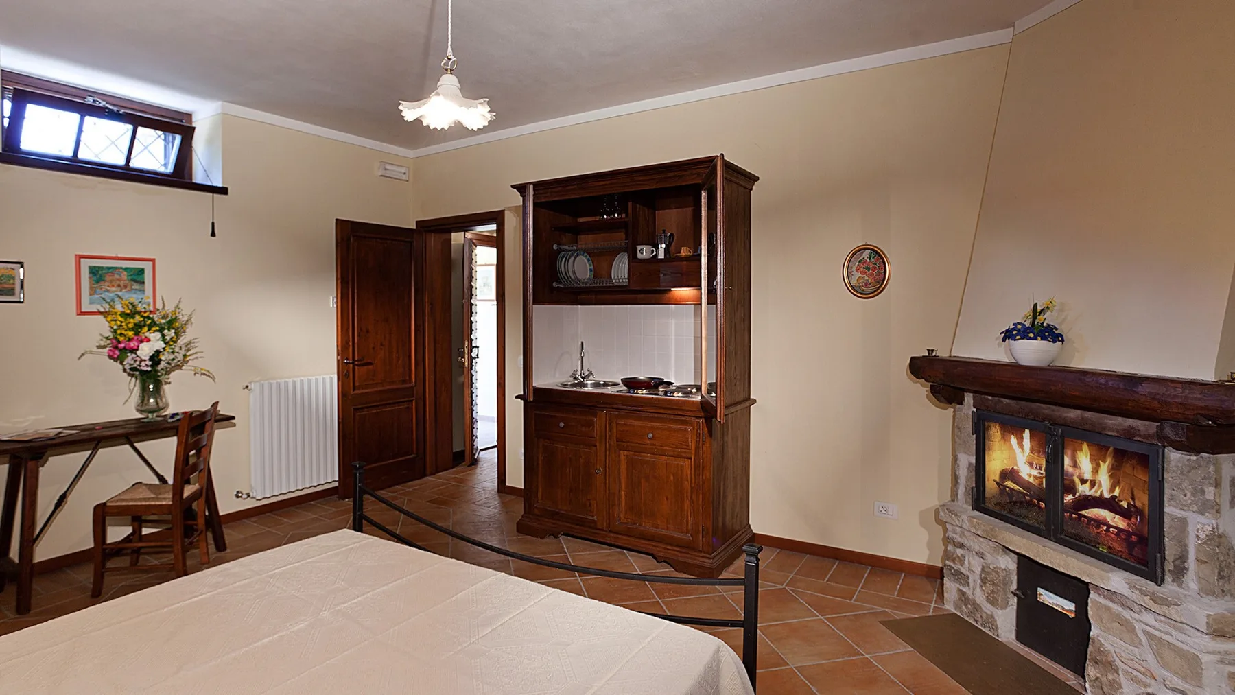 A living room with a wooden cabinet, dining table, and fireplace.