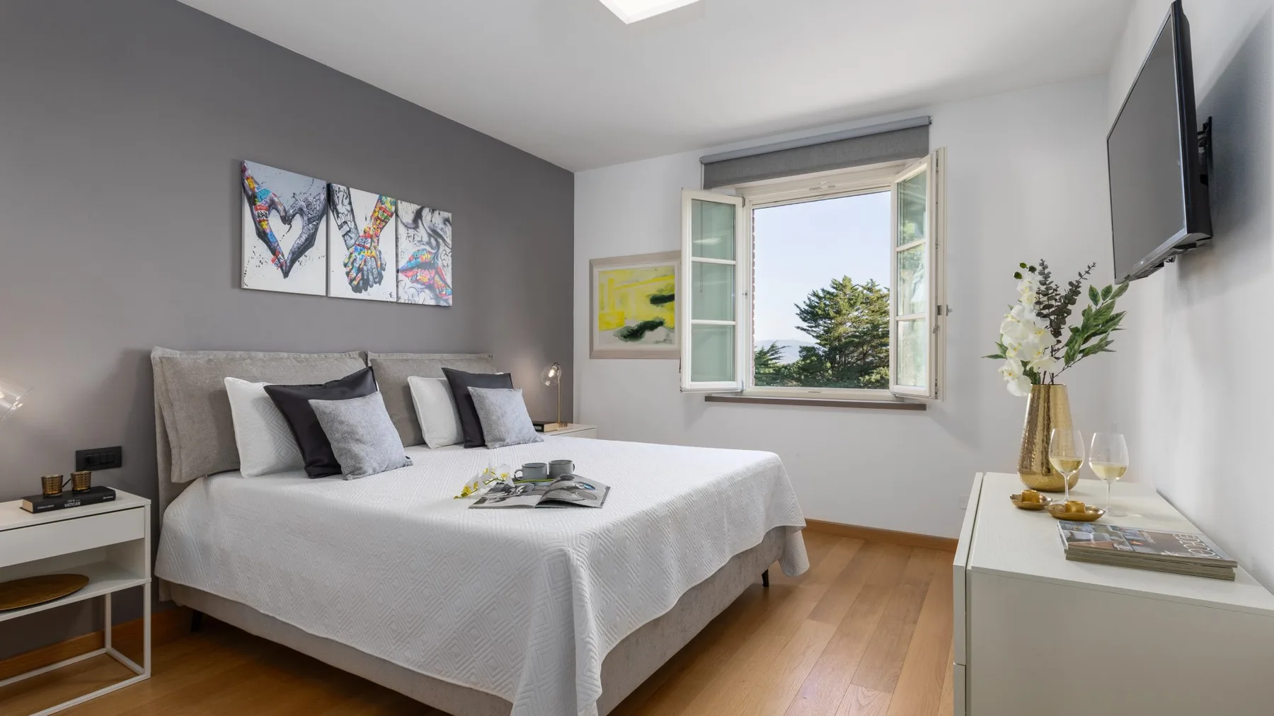 A bedroom with a neatly made bed and an open window.