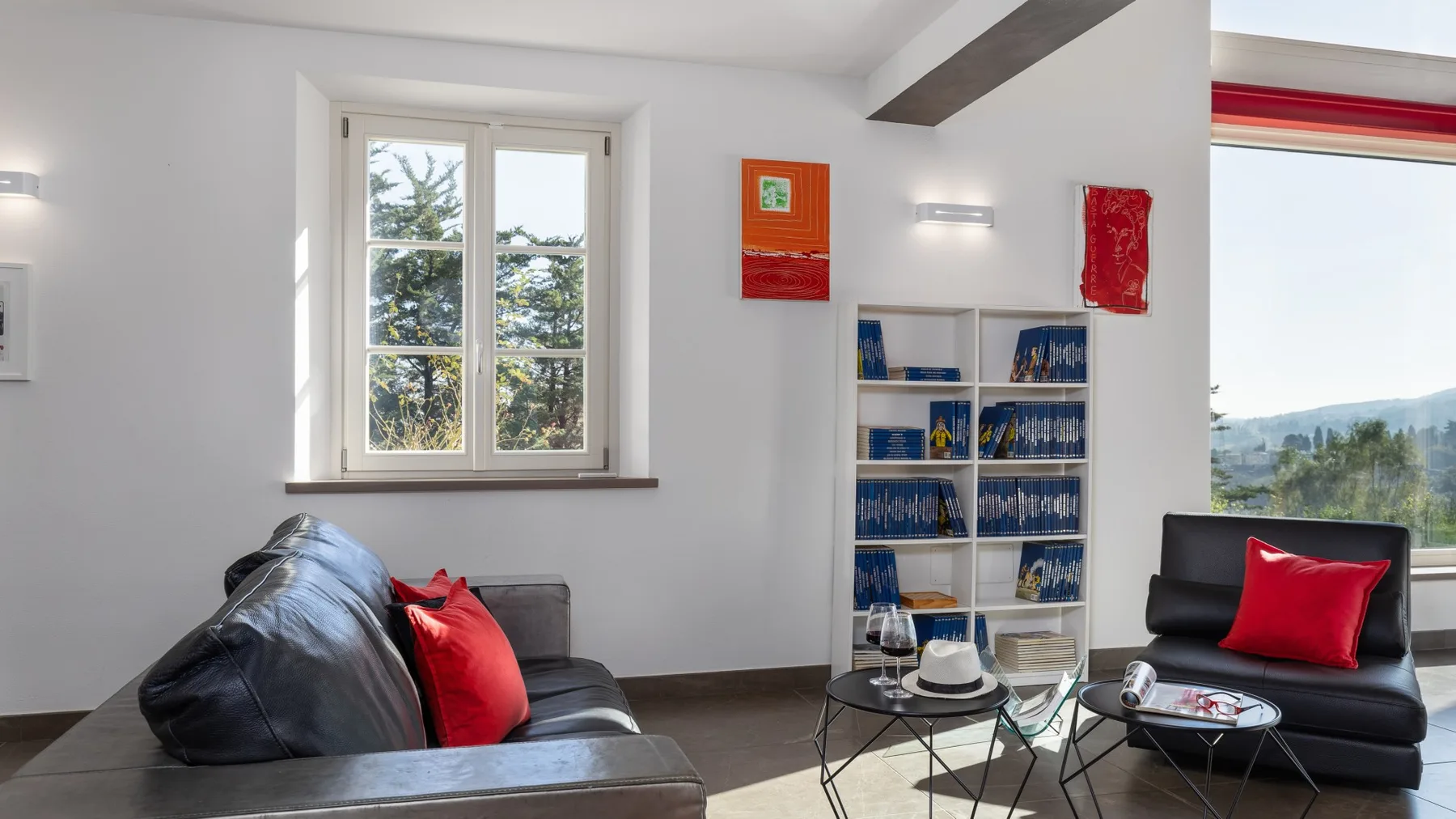A bright living room with seating, a coffee table, and a large window.