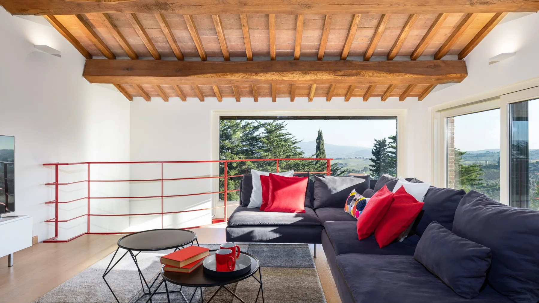A living room with a sectional seating area, coffee tables, and a large window.