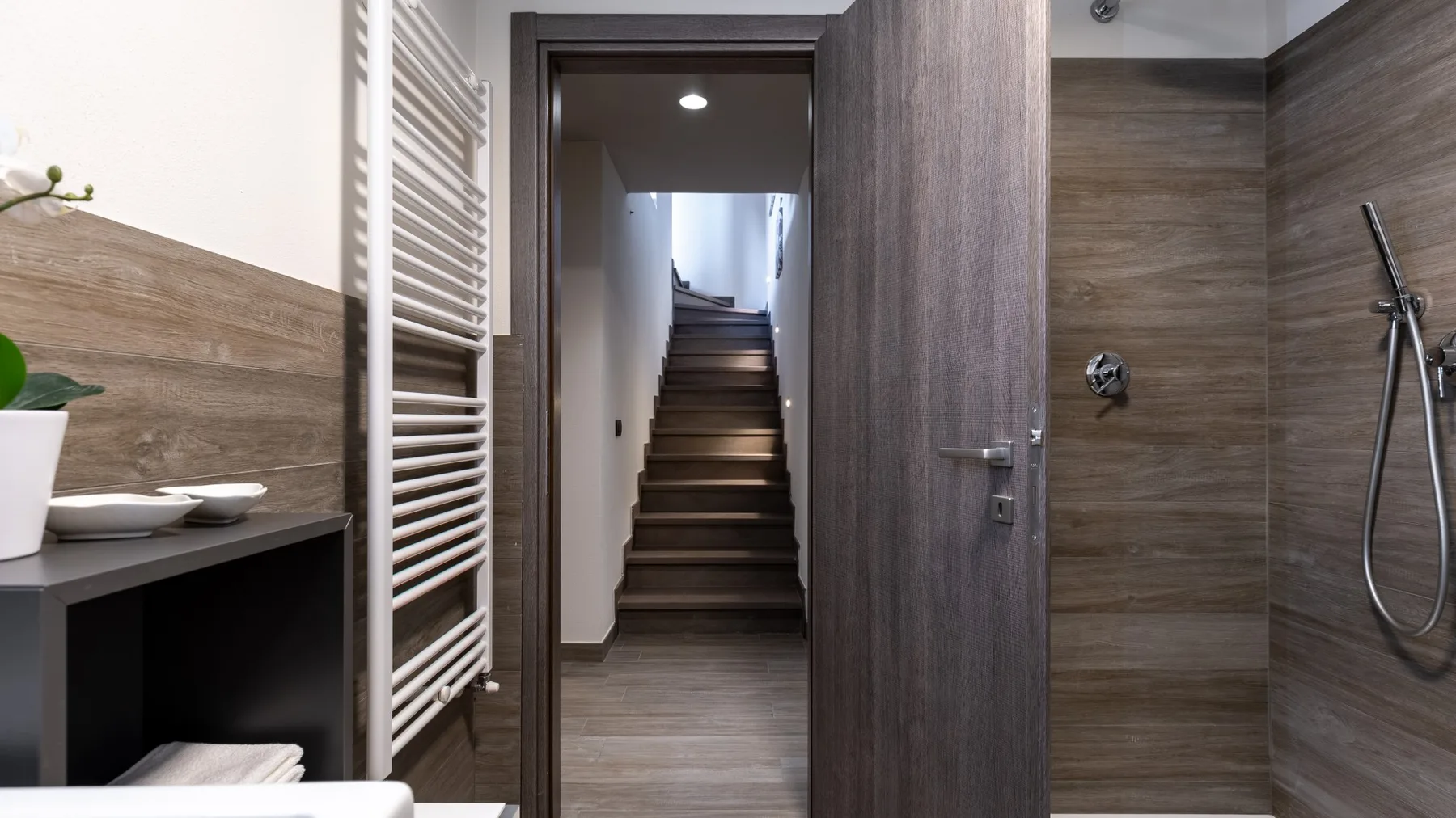 A bathroom entrance opens onto a staircase, with a shower visible on the right.