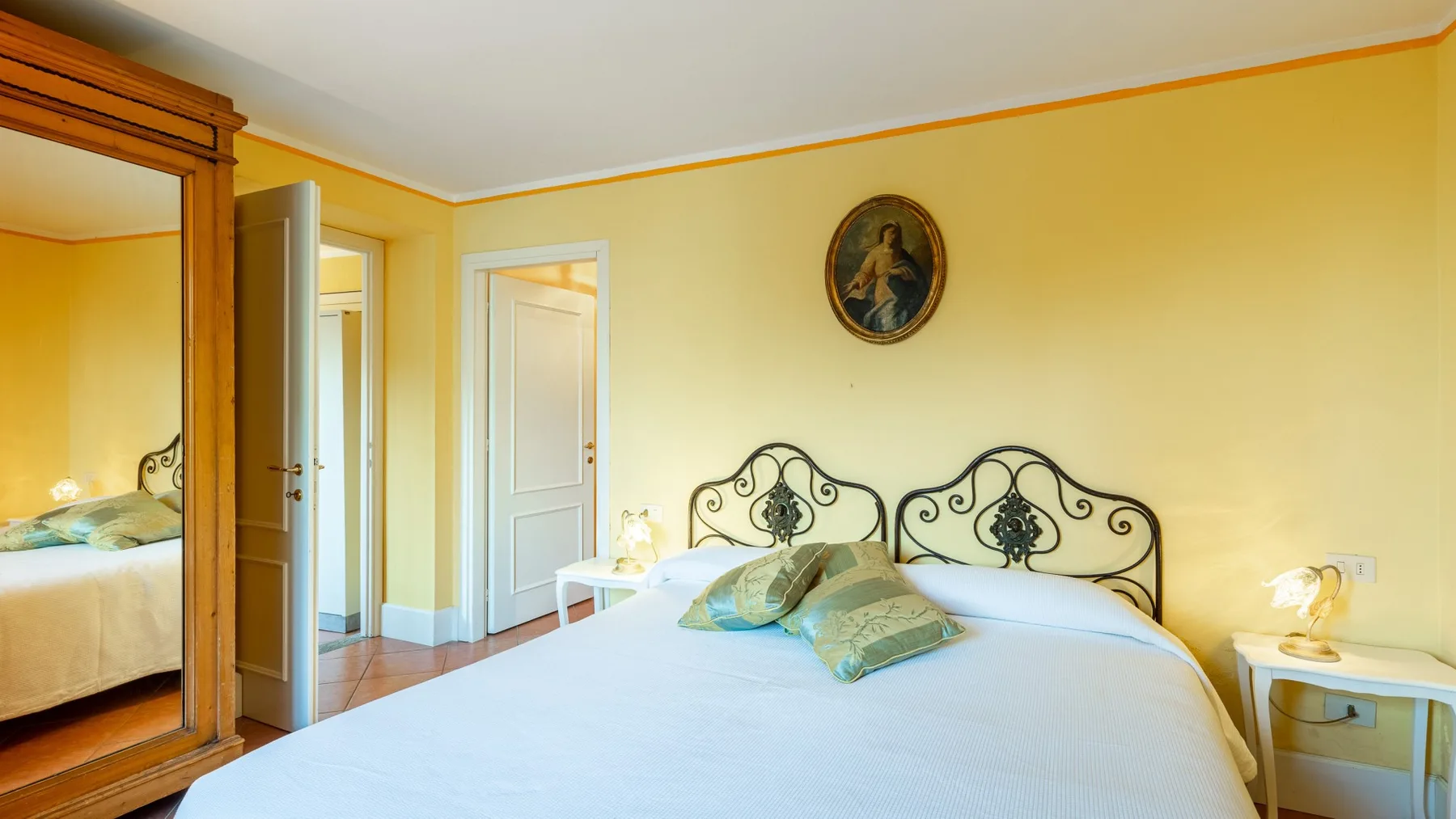 Un dormitorio con una cama bien tendida y paredes amarillas.