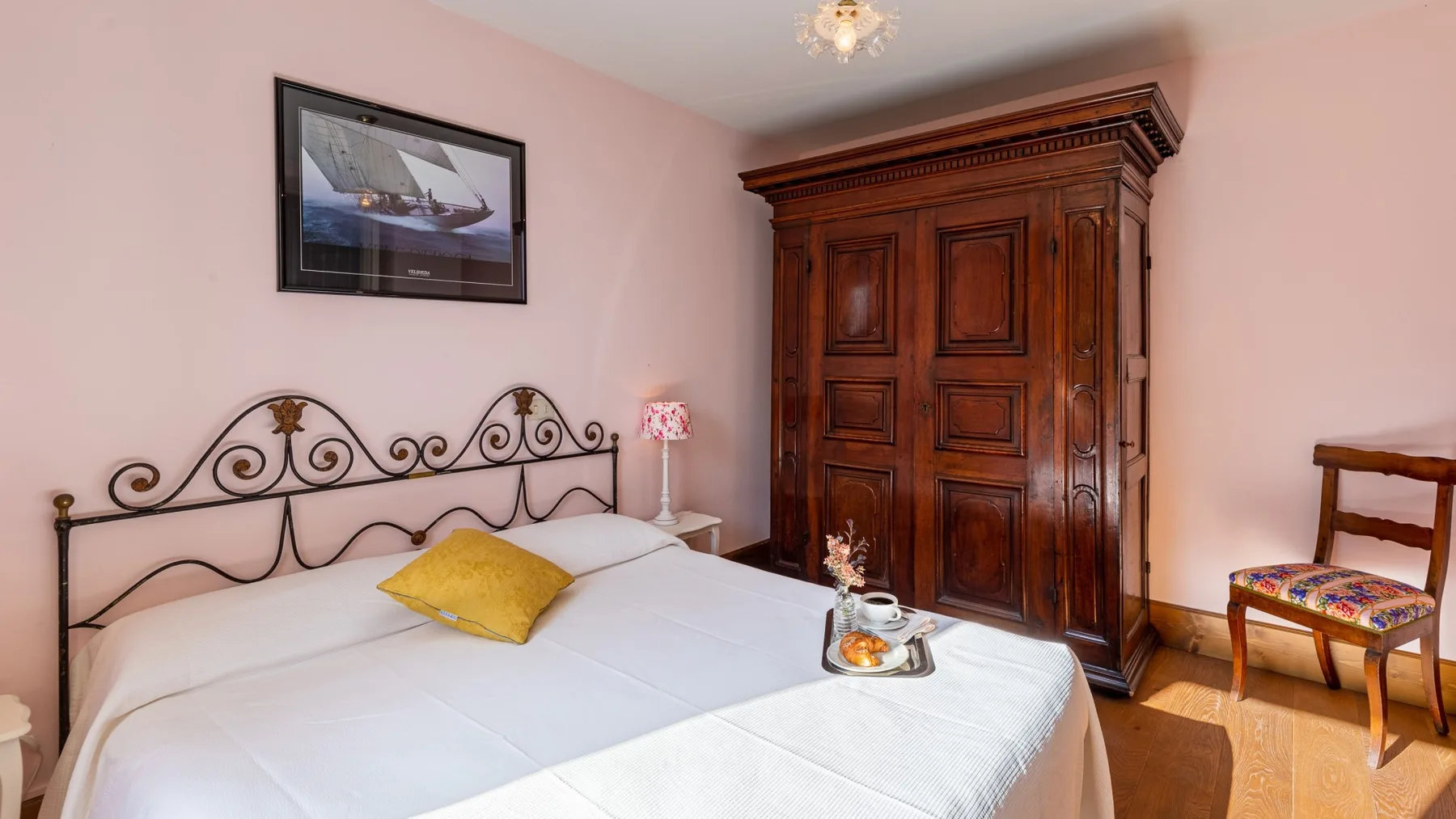 Un dormitorio con una cama bien tendida y un gran armario de madera.