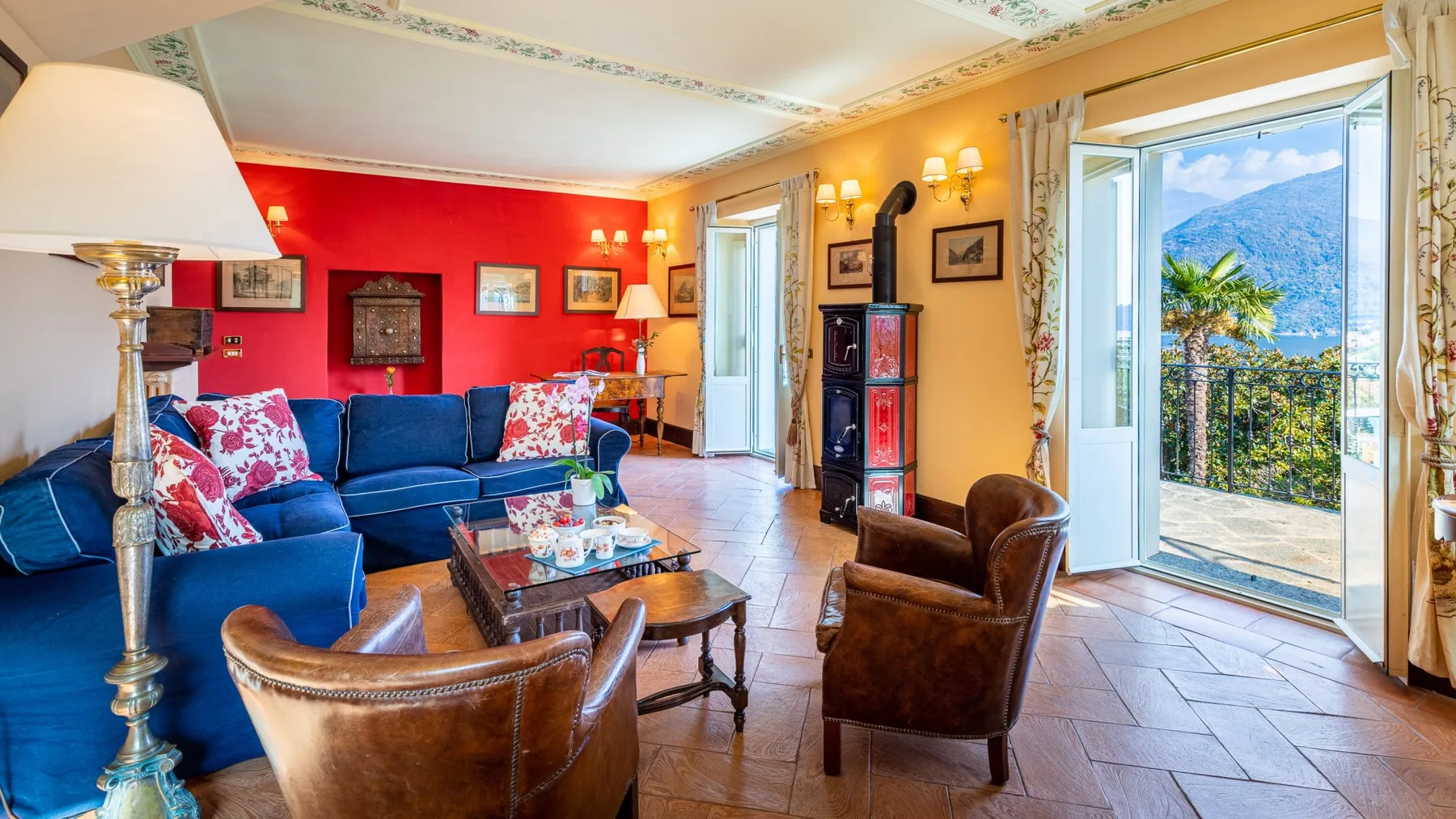 Una sala colorida con asientos azules y puertas abiertas a una vista de montañas.