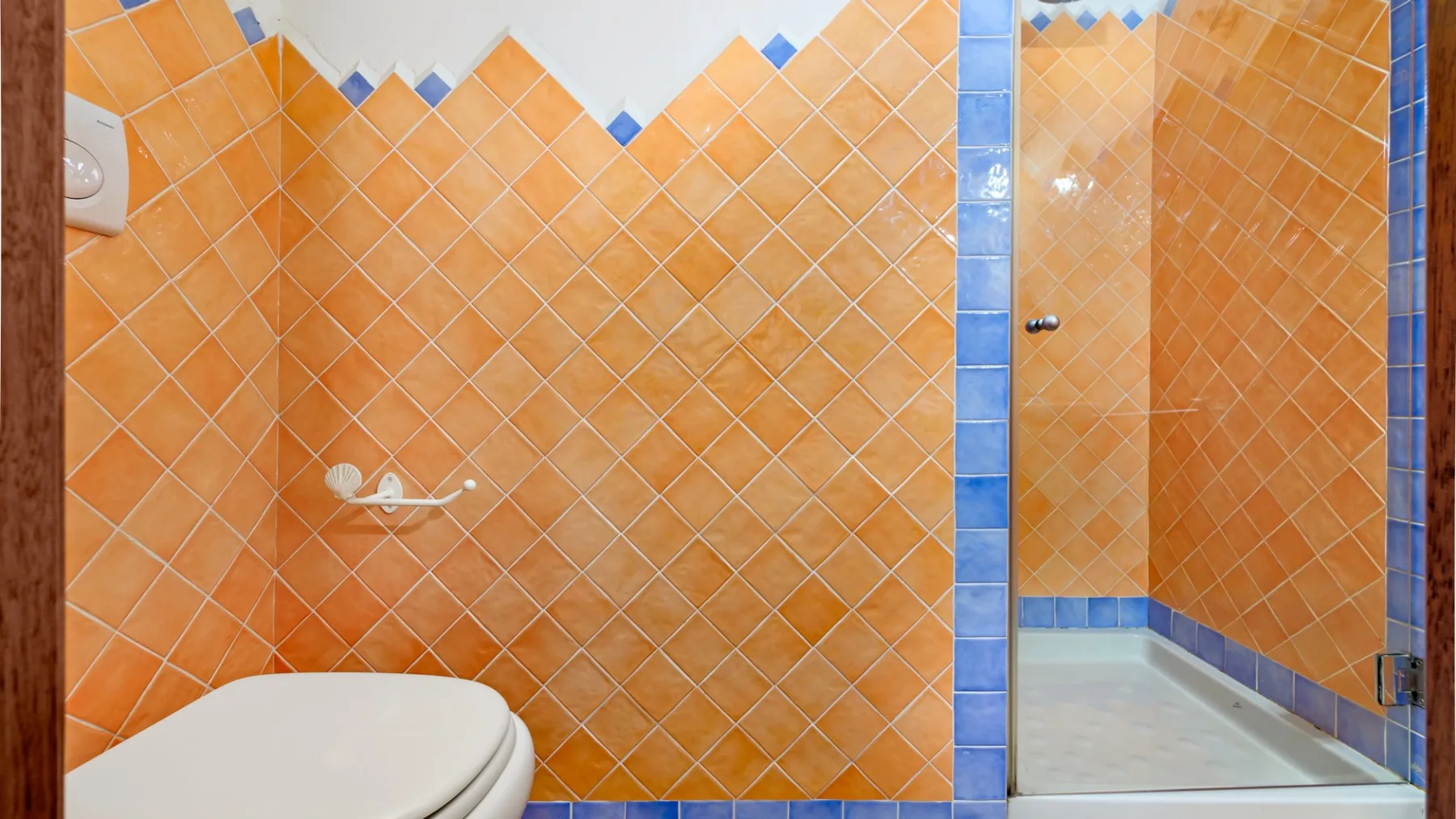 Un baño alicatado con ducha e inodoro.