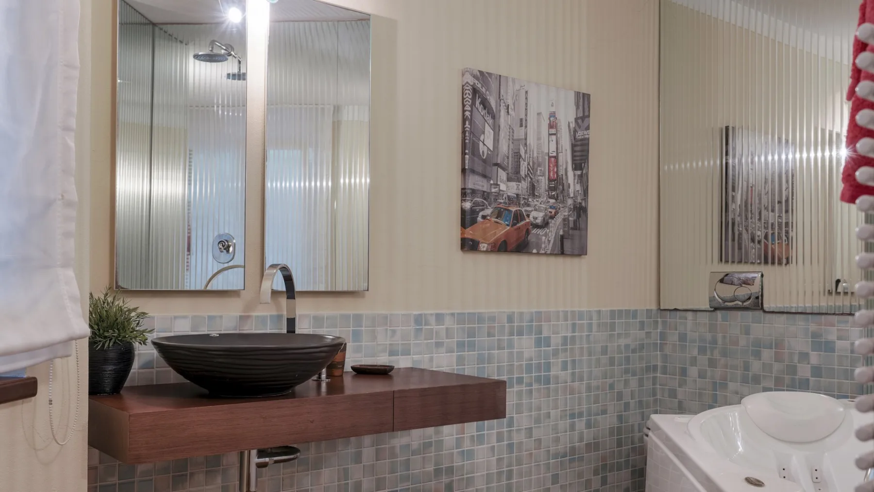 A bathroom vanity with a vessel sink and mirrored cabinet.