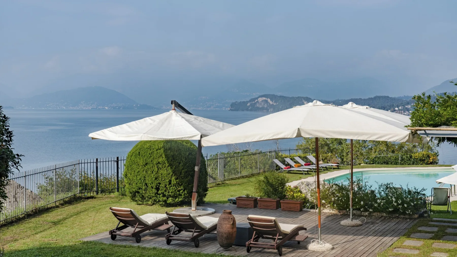 A waterfront patio with sun umbrellas and lounge seating overlooks the bay.