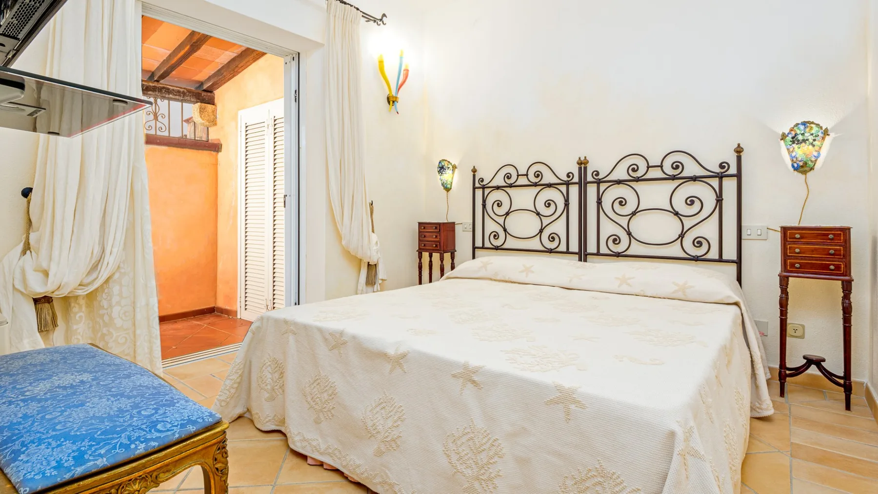 Un dormitorio con una cama grande y un cabecero decorativo de metal.