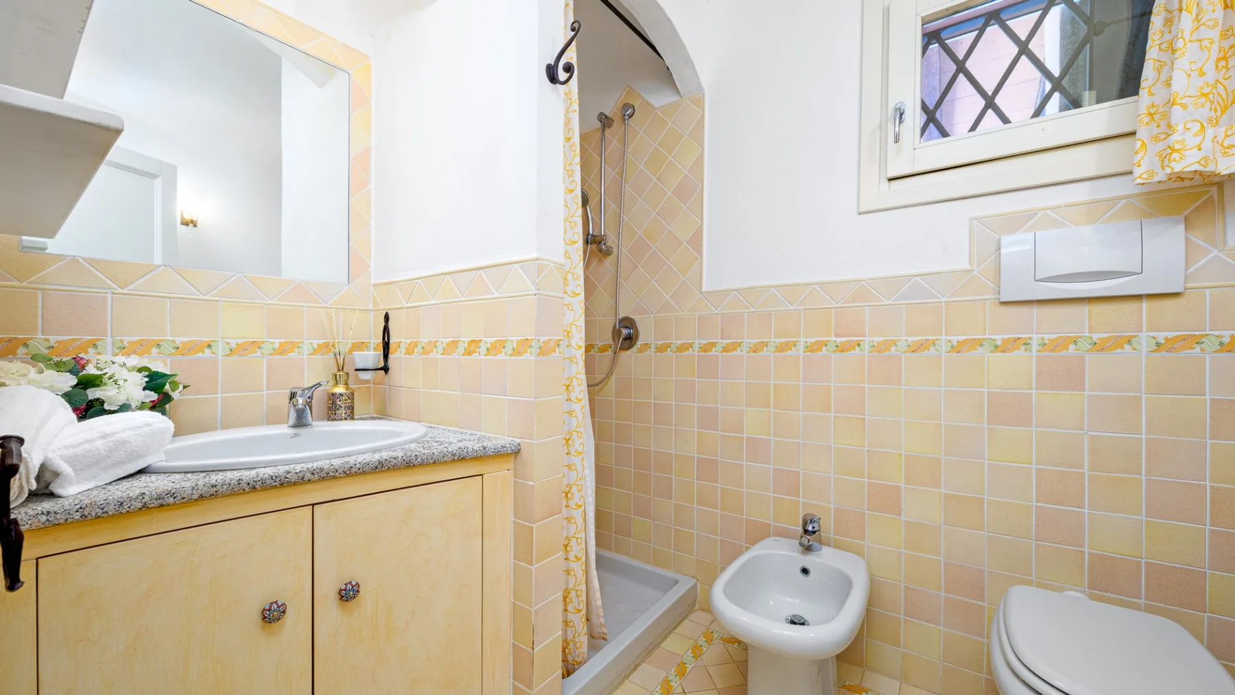Un baño con azulejos, lavabo, inodoro y zona de ducha.