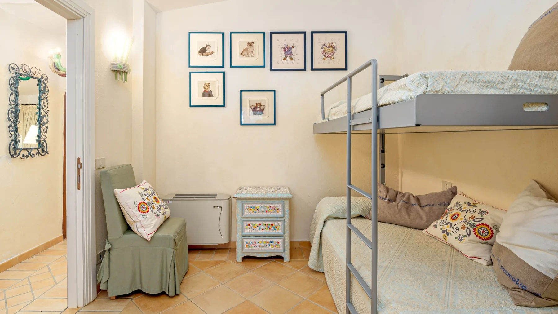 Un dormitorio con literas, una cómoda pequeña y cuadros en la pared.