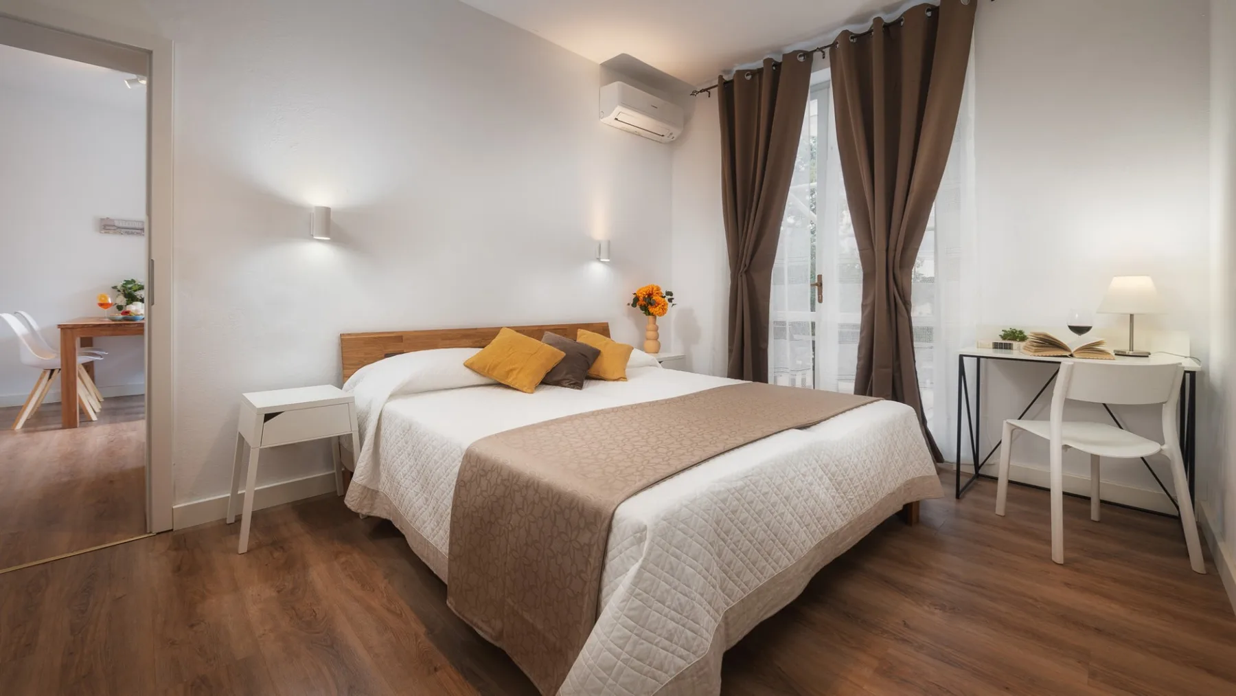 Un dormitorio con una cama bien hecha y cortinas marrones junto a la ventana.