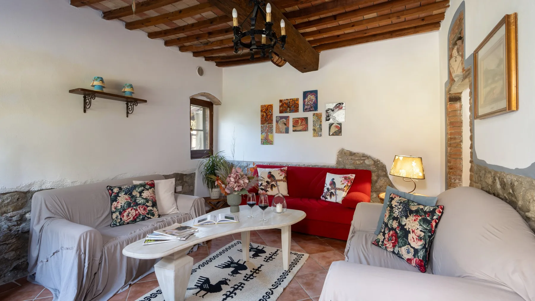 A living room with seating around a white coffee table and colorful wall art.