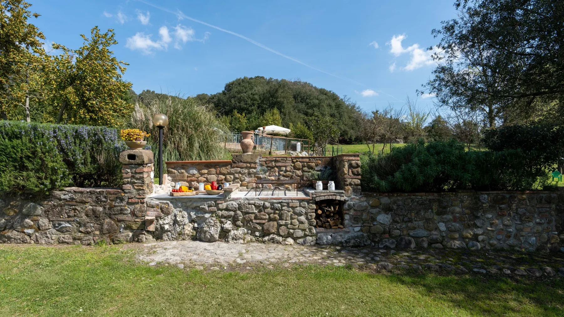 A garden patio with stone walls, steps, and an outdoor dining table.