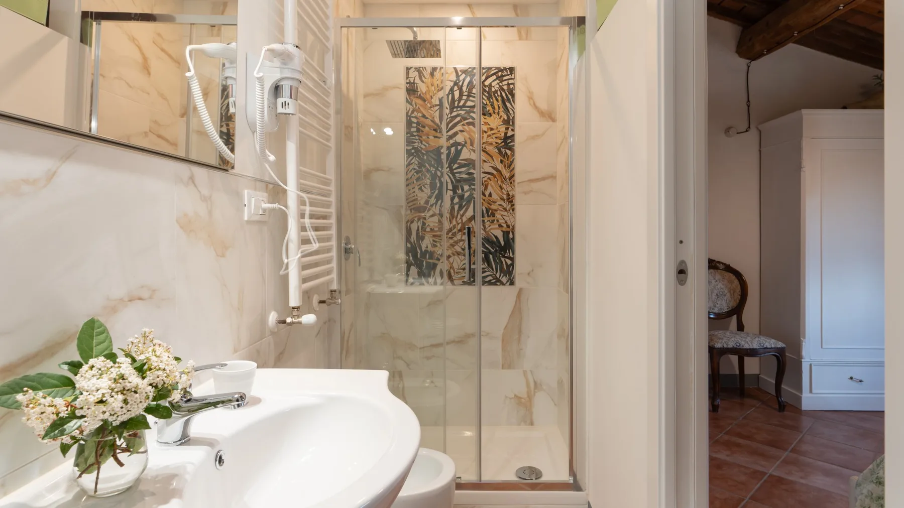 A bathroom with a sink and a glass shower enclosure.