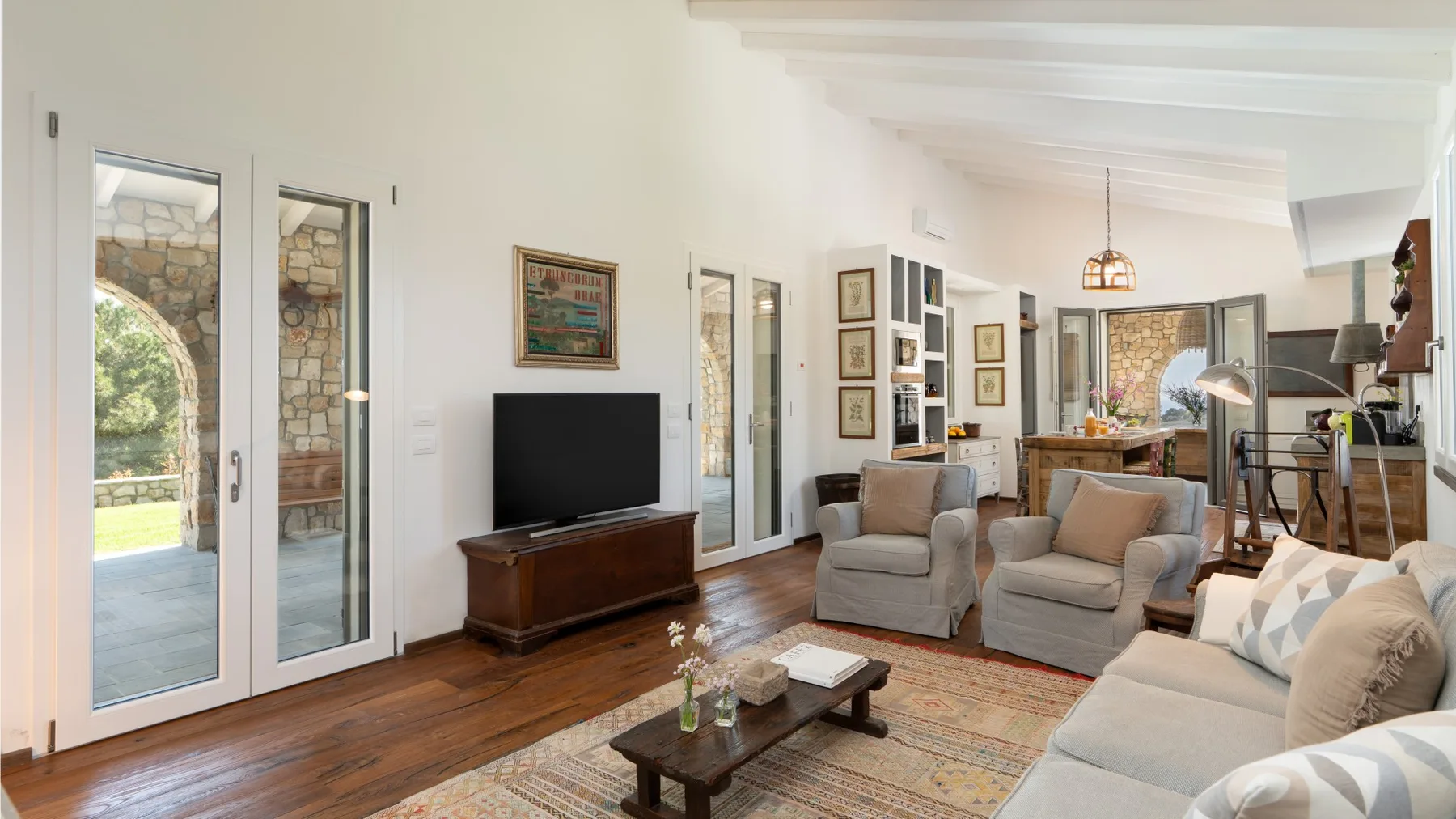 A bright living room with seating, a television, and a coffee table.