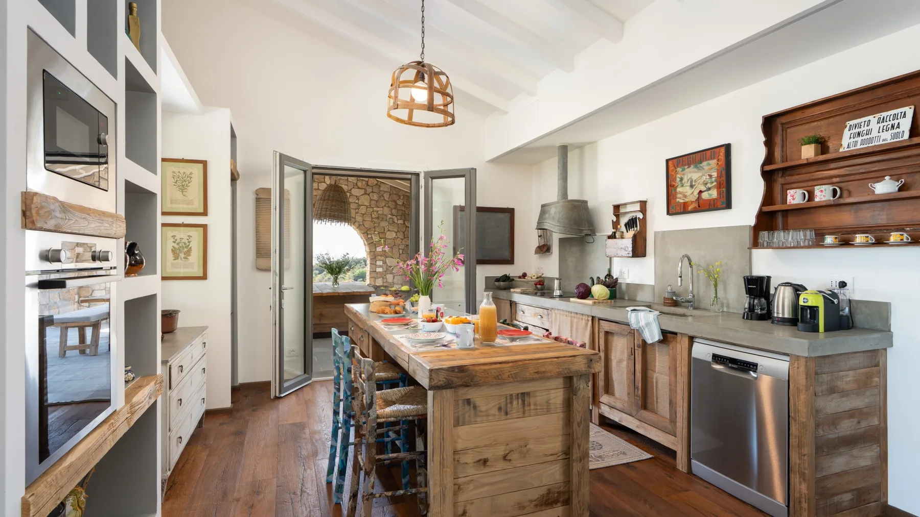 A bright kitchen with a wooden island and open doors leading to a patio.