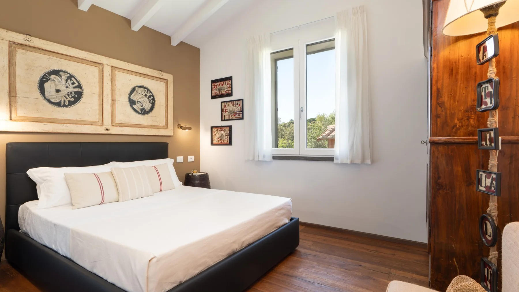 A bedroom with a large bed beside a bright window.