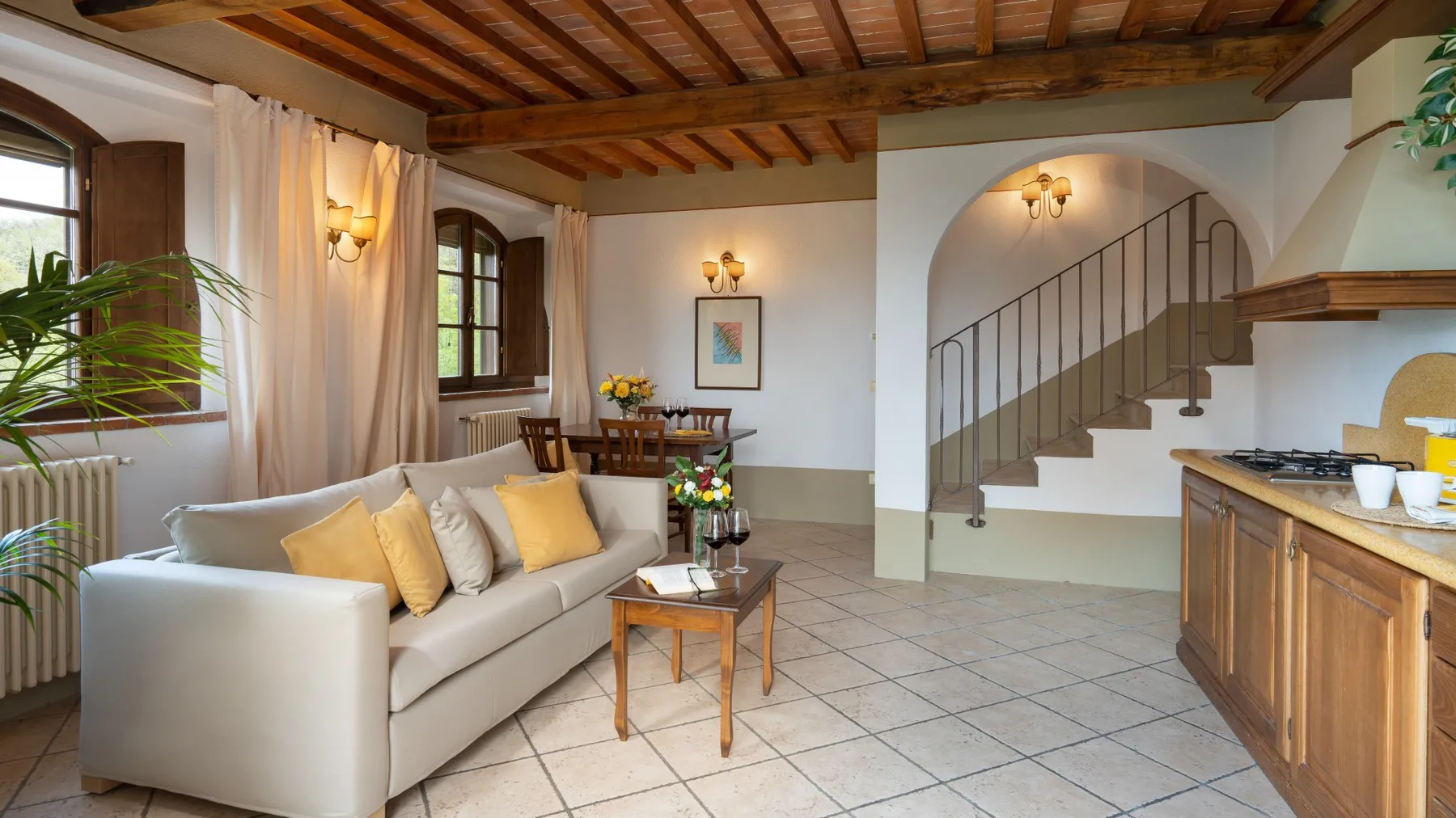 Una sala luminosa con asientos, suelo de baldosas y una escalera.