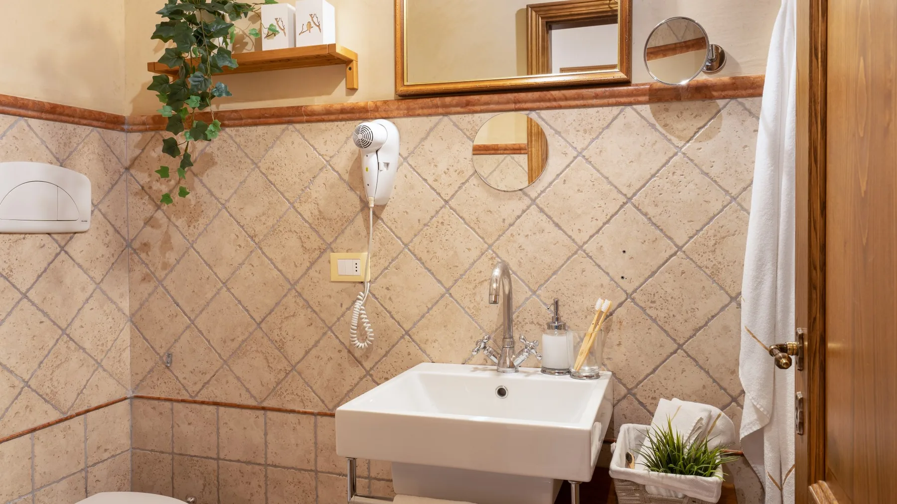 Un baño con azulejos, lavabo suspendido, espejo y cortina de ducha.