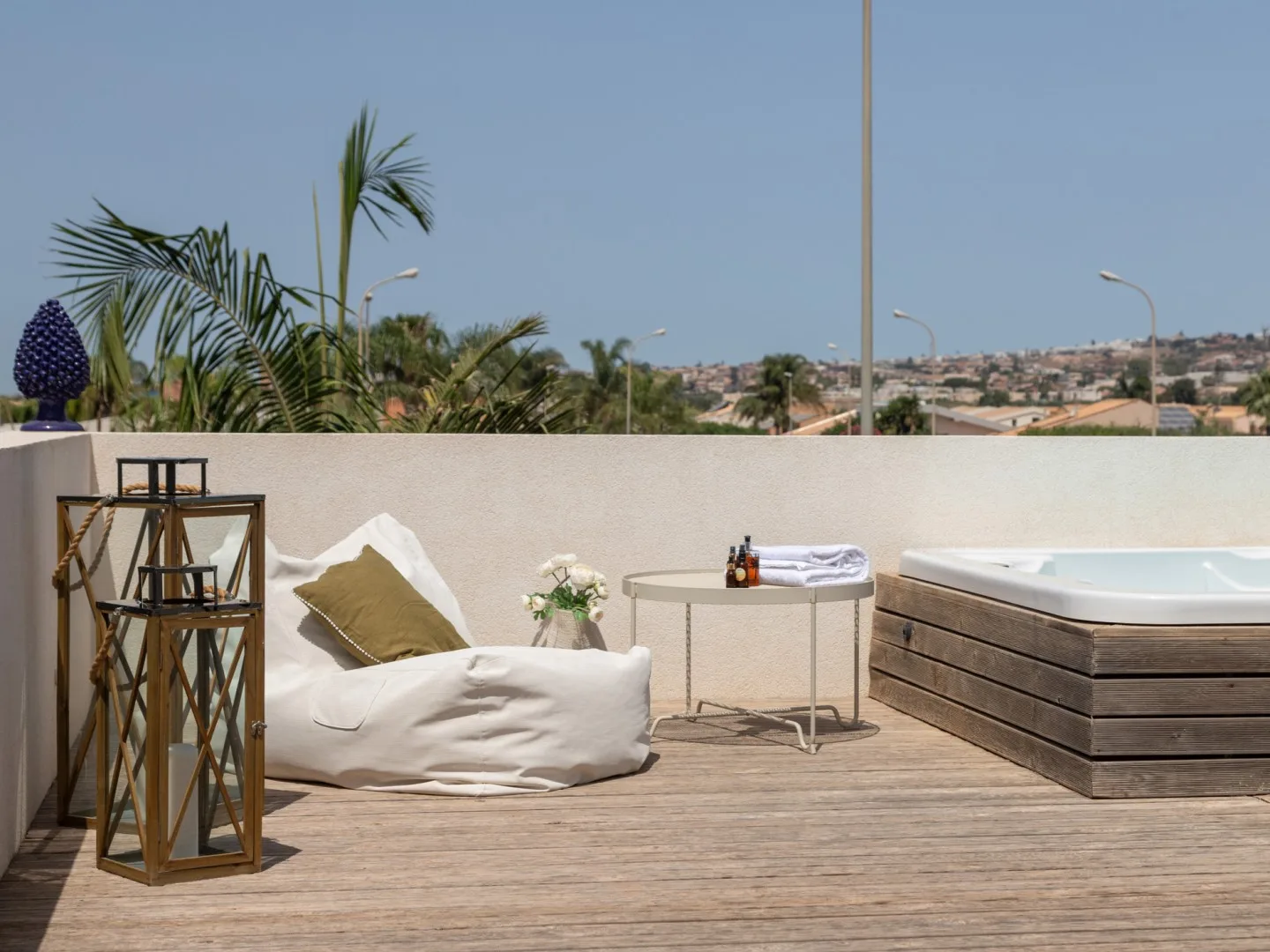 A rooftop terrace with outdoor seating, a small table, and a hot tub.