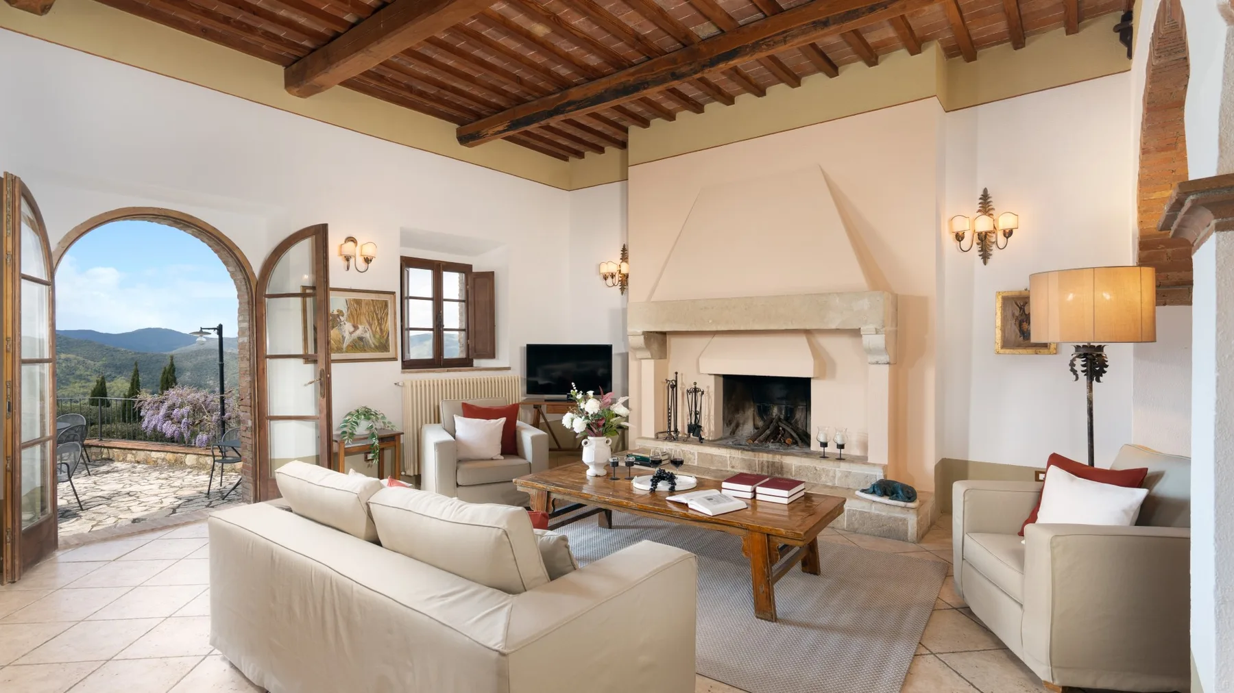 Una sala luminosa con asientos alrededor de una chimenea y una mesa de centro.