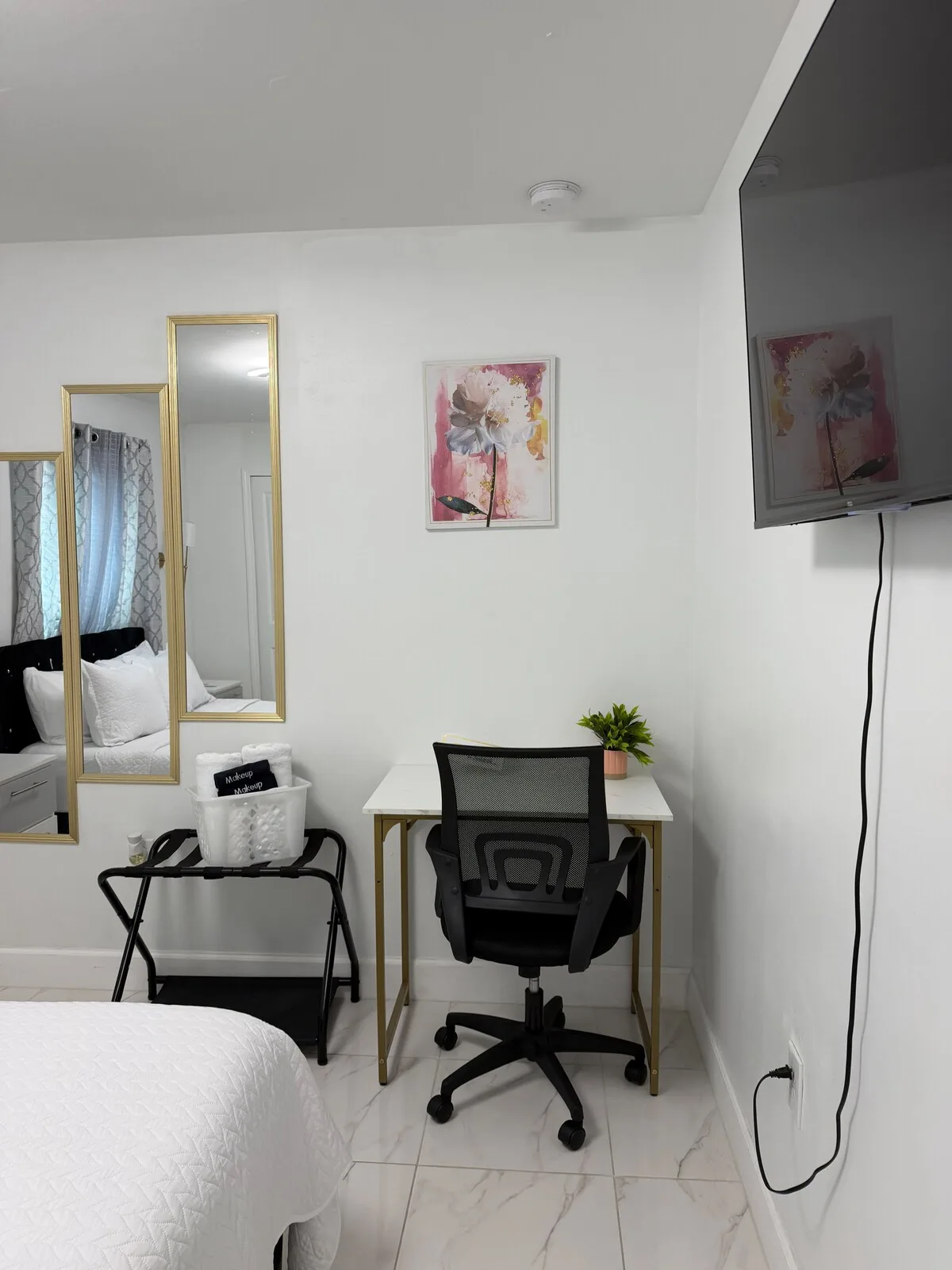 A bedroom with a desk and chair beside the bed.