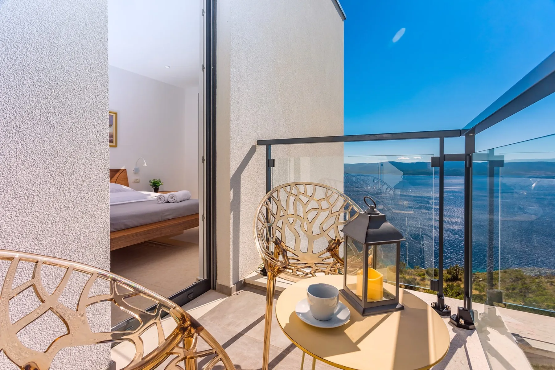 A balcony seating area overlooks a broad mountain landscape.