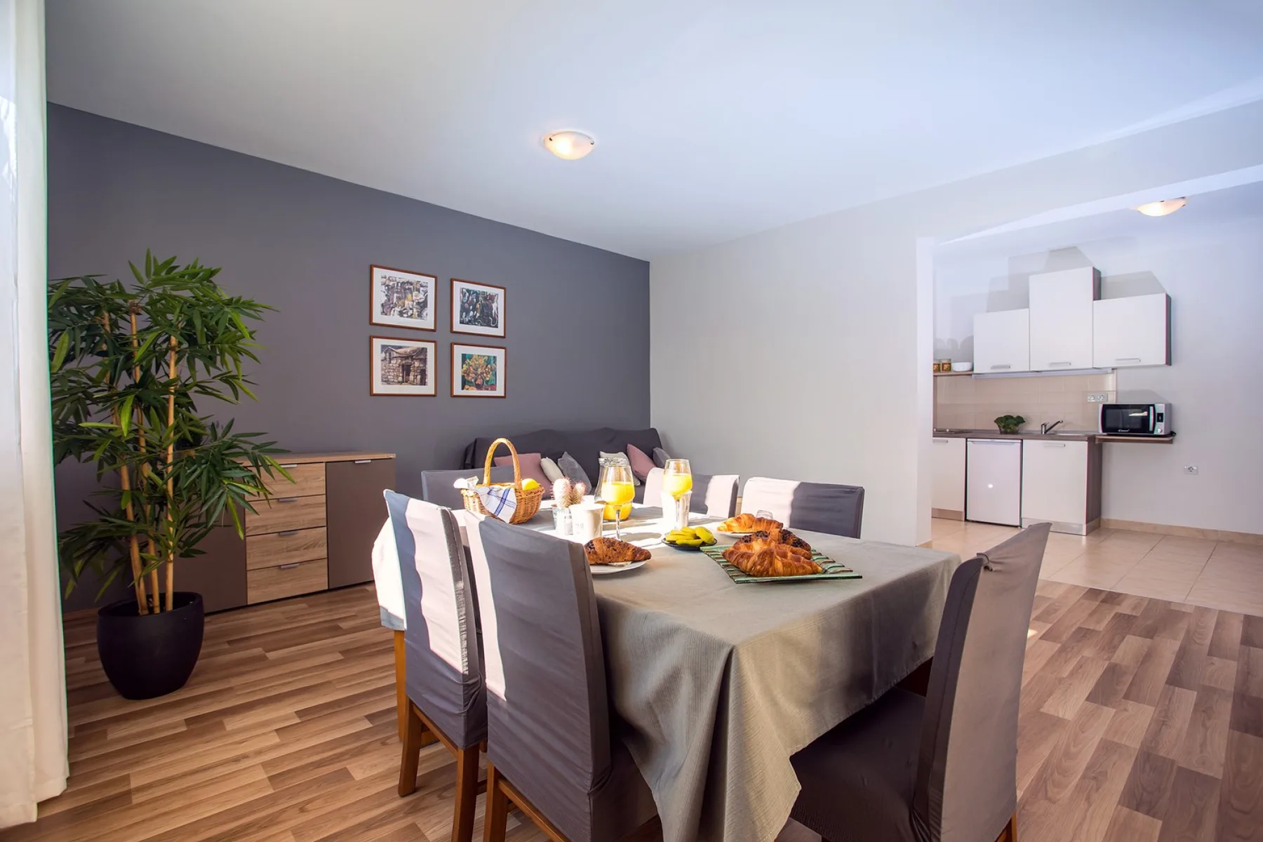Comedor con la mesa puesta junto a una cocina abierta.