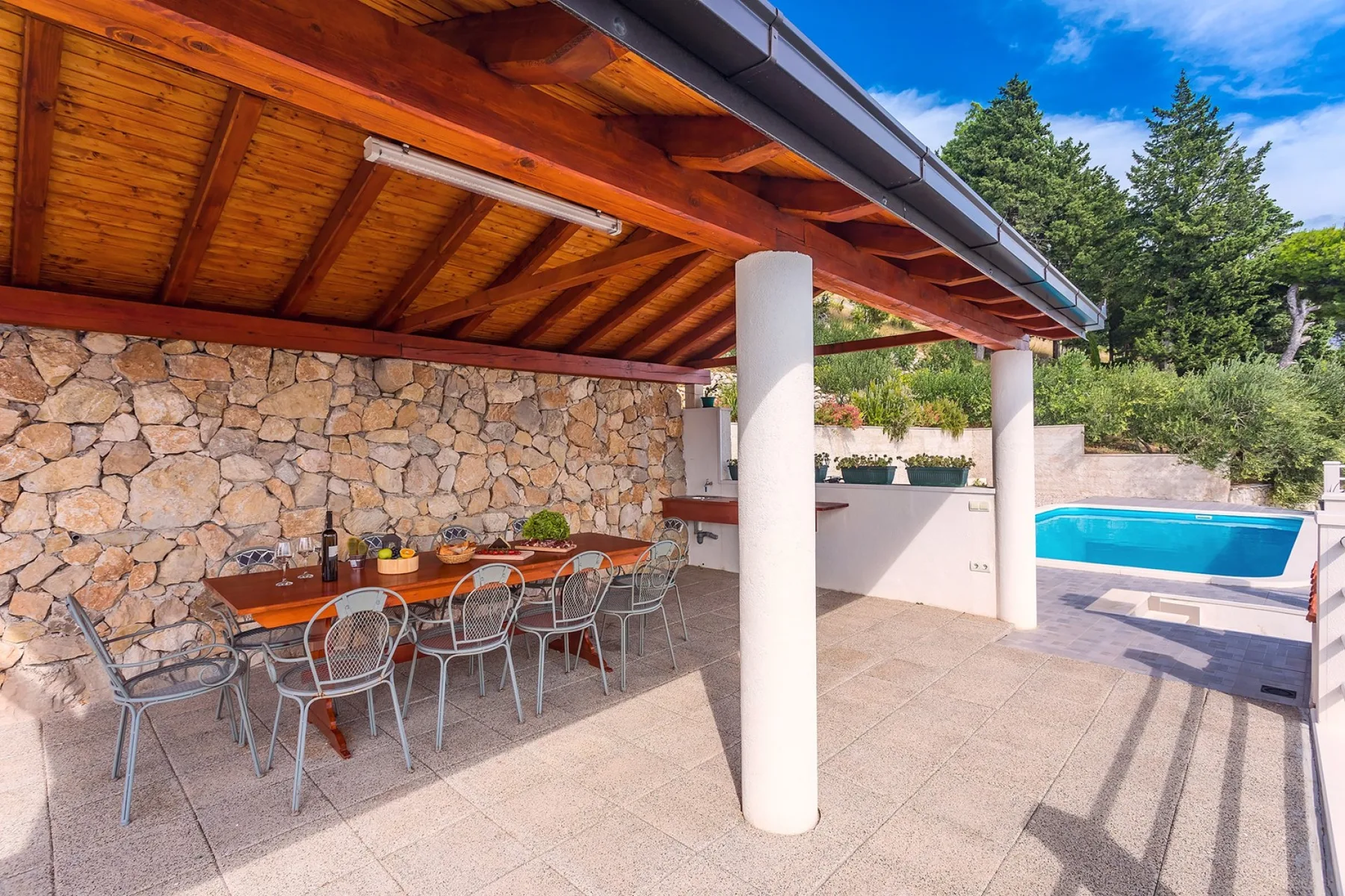 Una zona de comedor exterior cubierta con una mesa junto a una piscina.