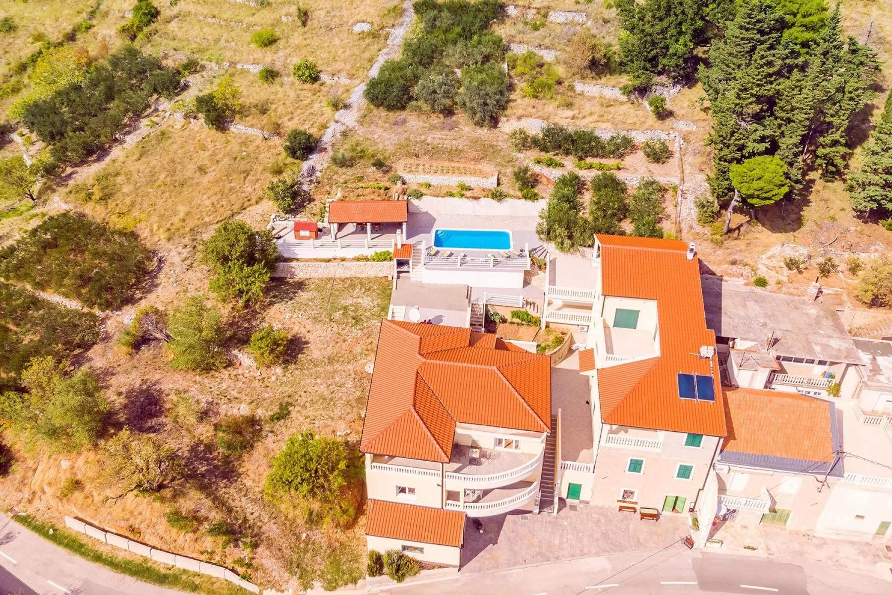 Vista aérea de una casa con tejados de terracota y una piscina.