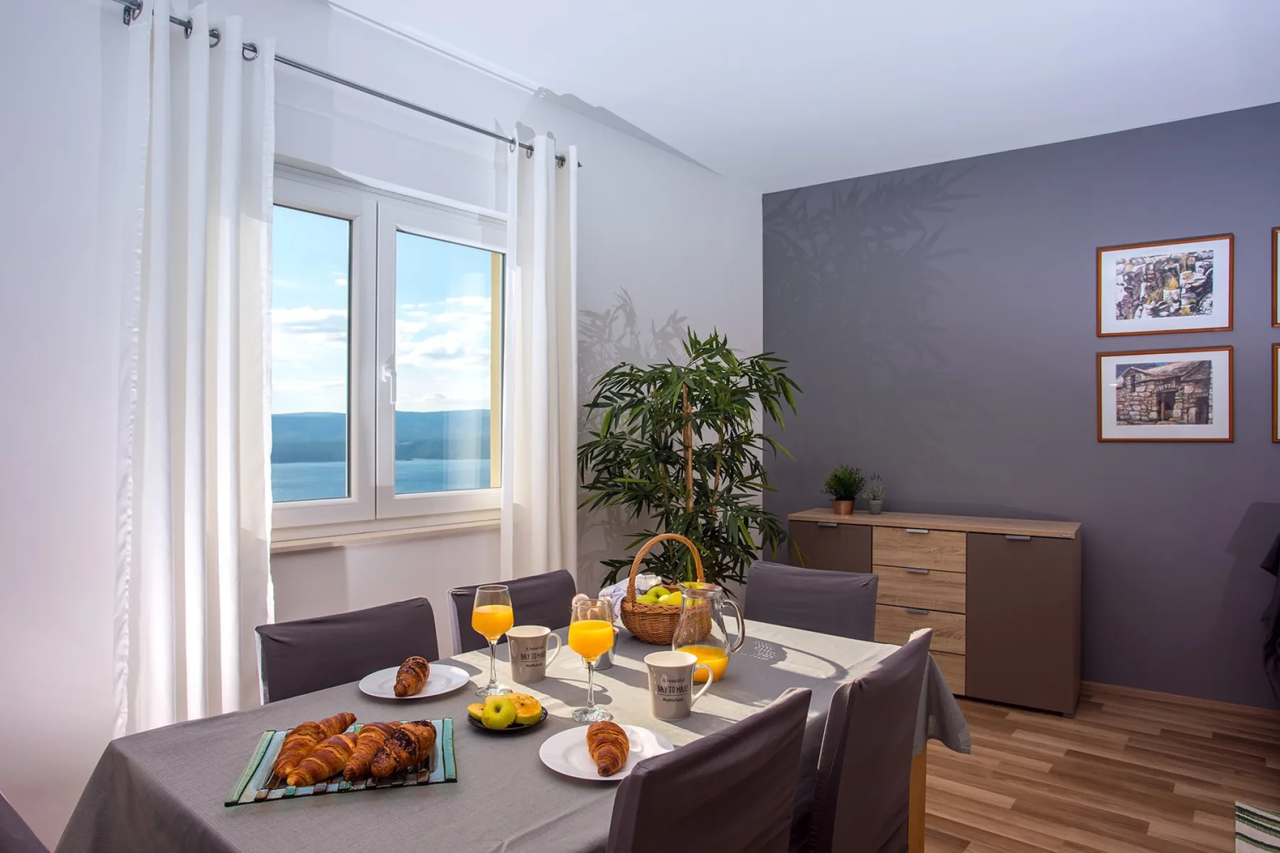 Comedor con una mesa puesta junto a una ventana con vistas al agua.