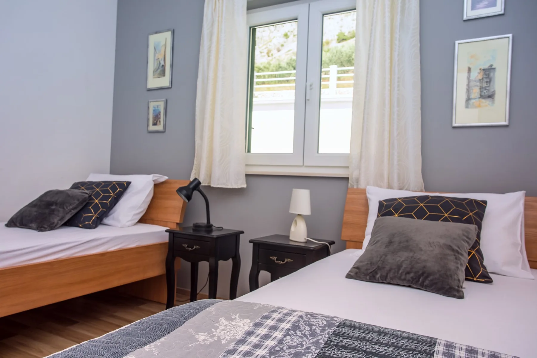 Un dormitorio con dos camas, mesitas de noche y una ventana con cortinas.