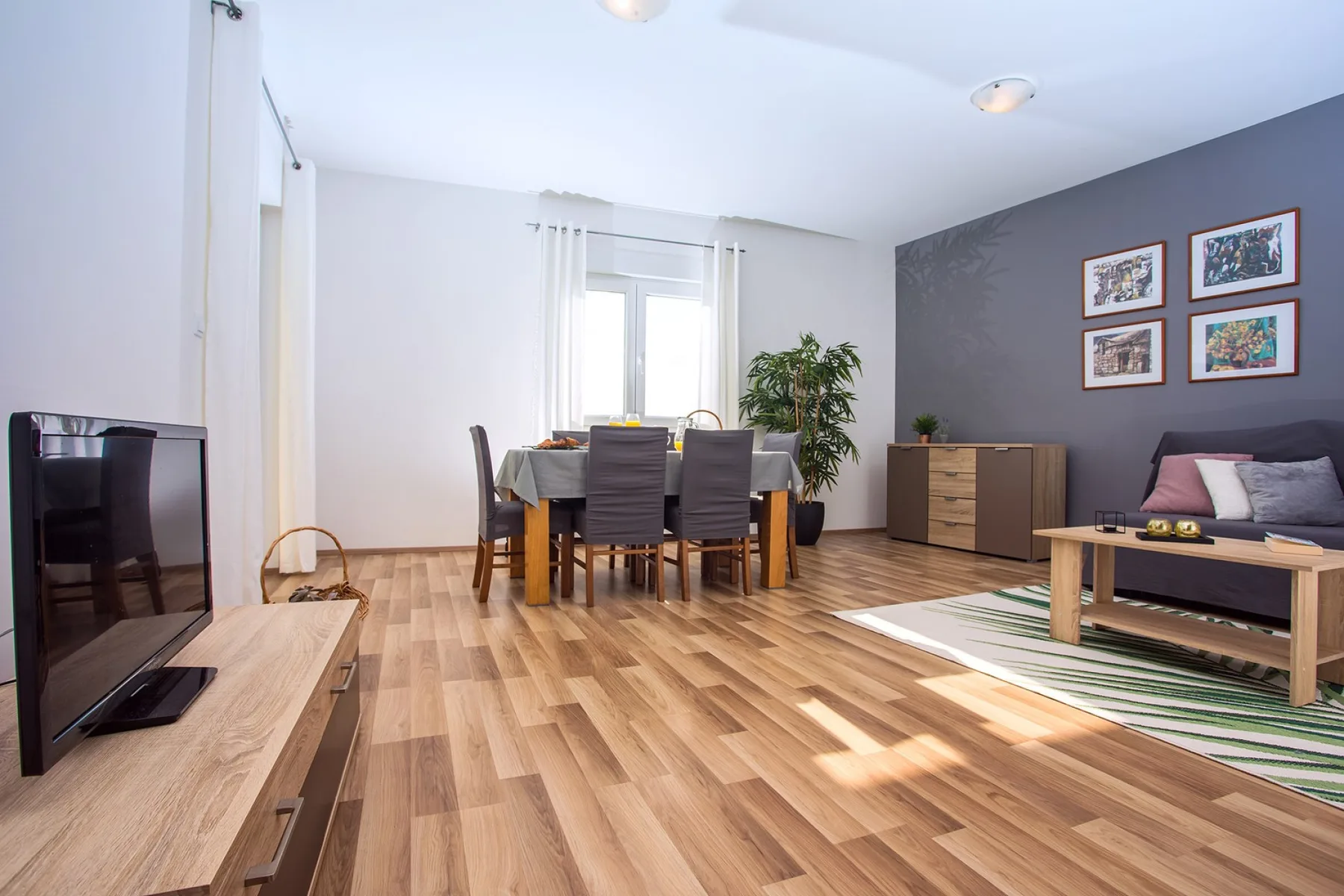 Un salón-comedor luminoso con una mesa de comedor y una zona de estar.