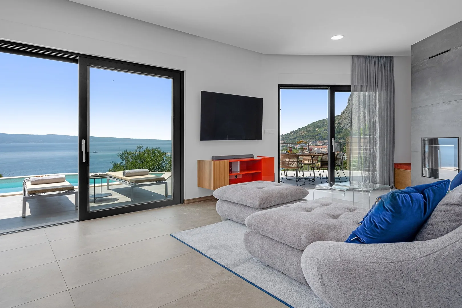 A bright living room opens onto a terrace with views of the sea.