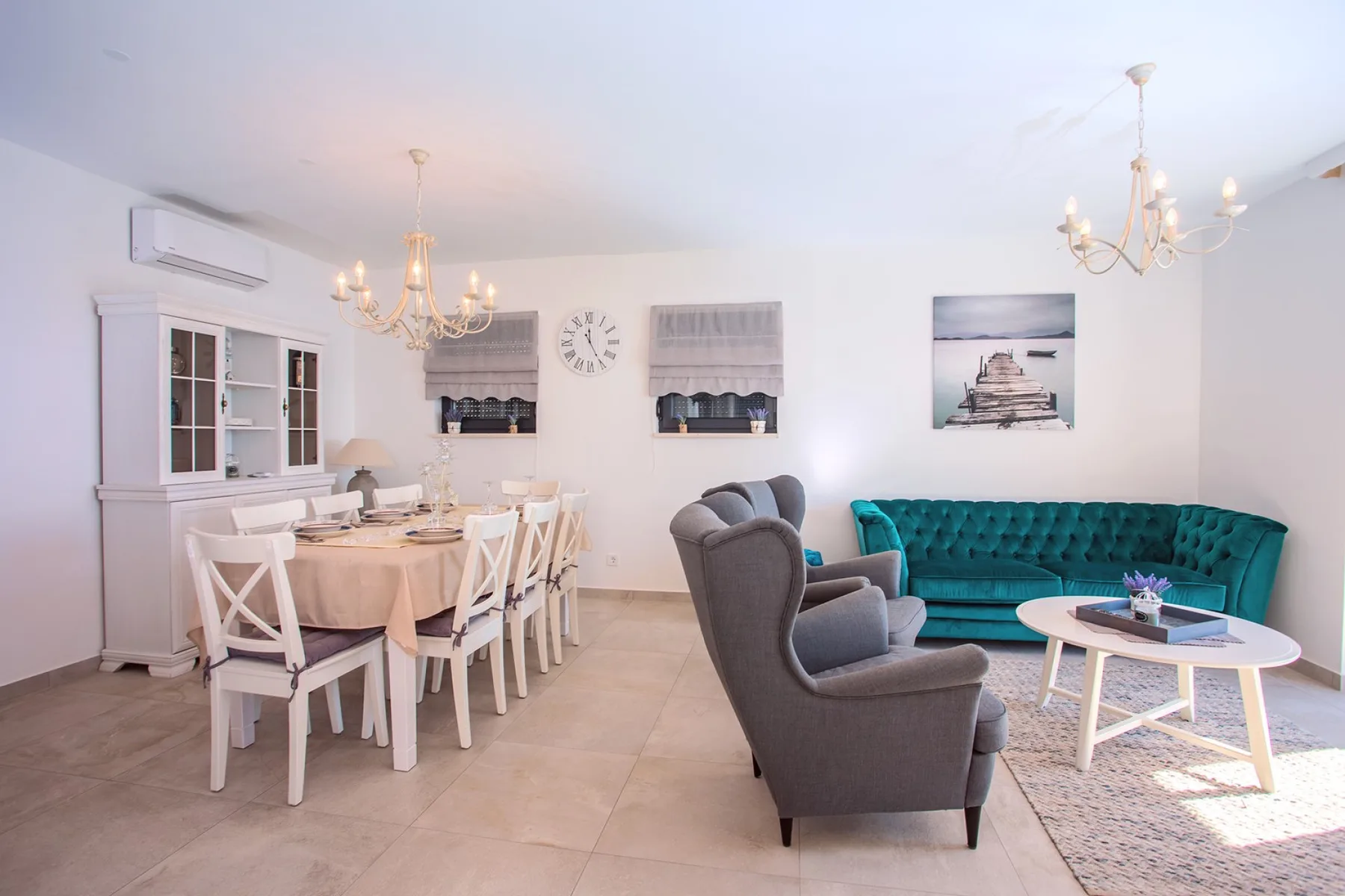 A bright living and dining room with seating around a coffee table.