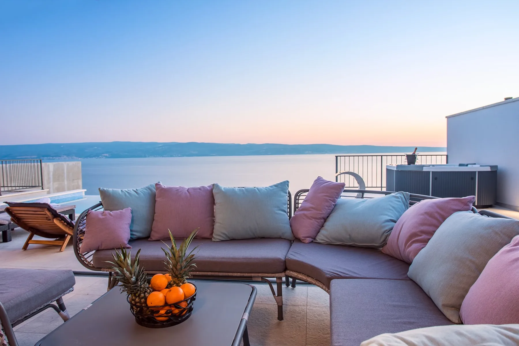 A rooftop terrace with outdoor seating overlooks the water.
