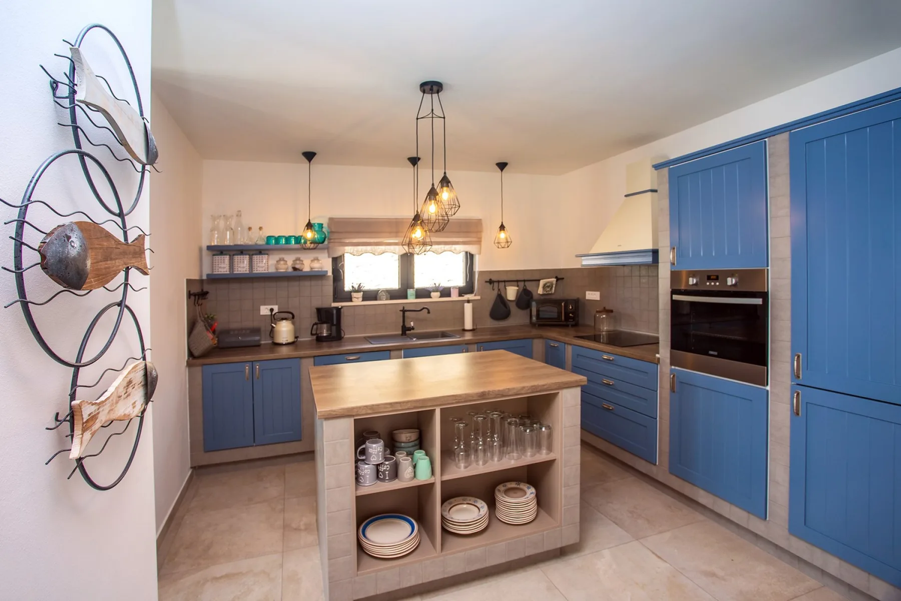 A spacious kitchen with blue cabinetry and a central island.