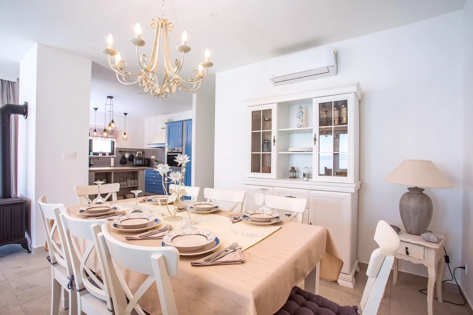 A dining room with a set table and a white display cabinet.