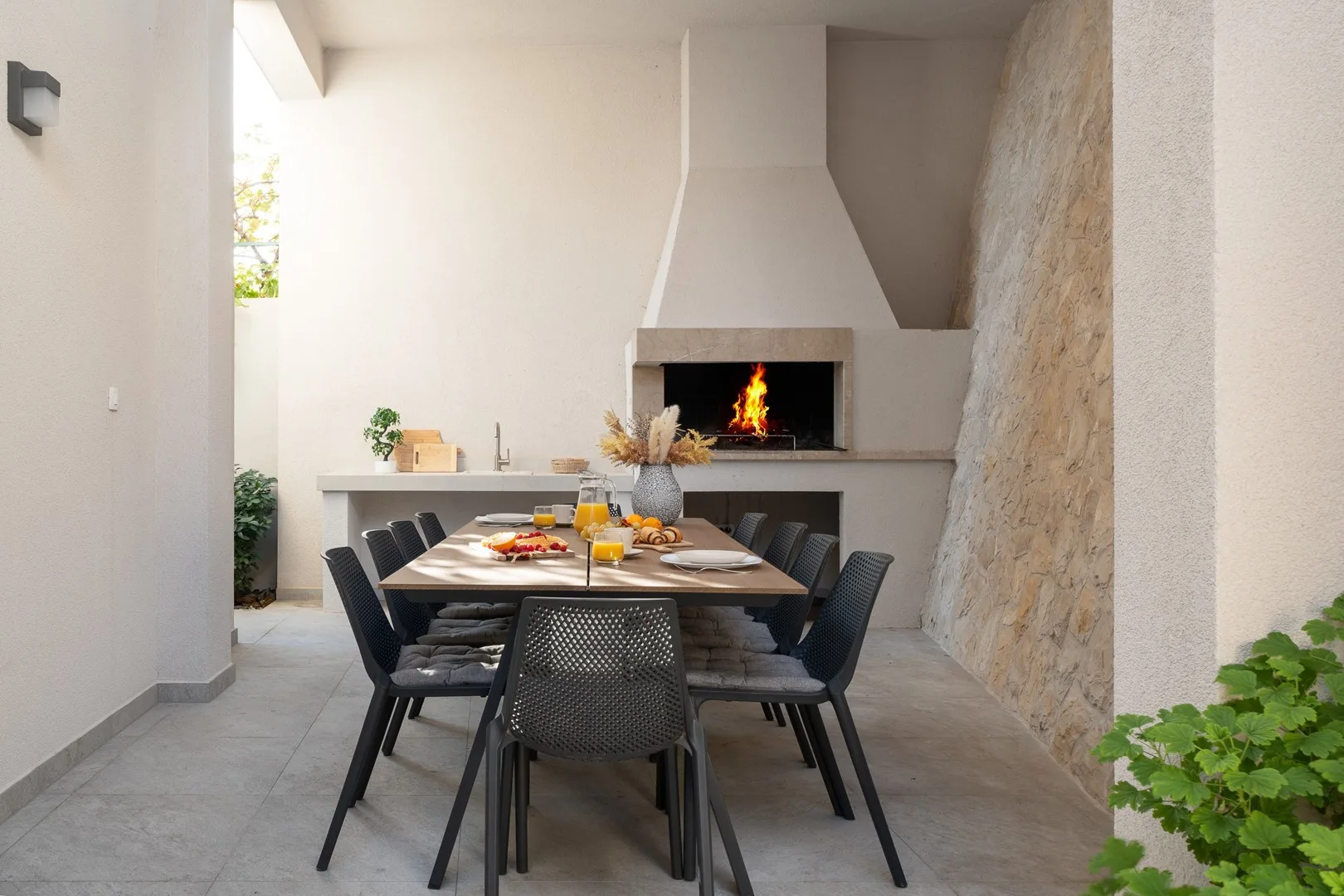 A dining area with a long table and a fireplace at the far end.