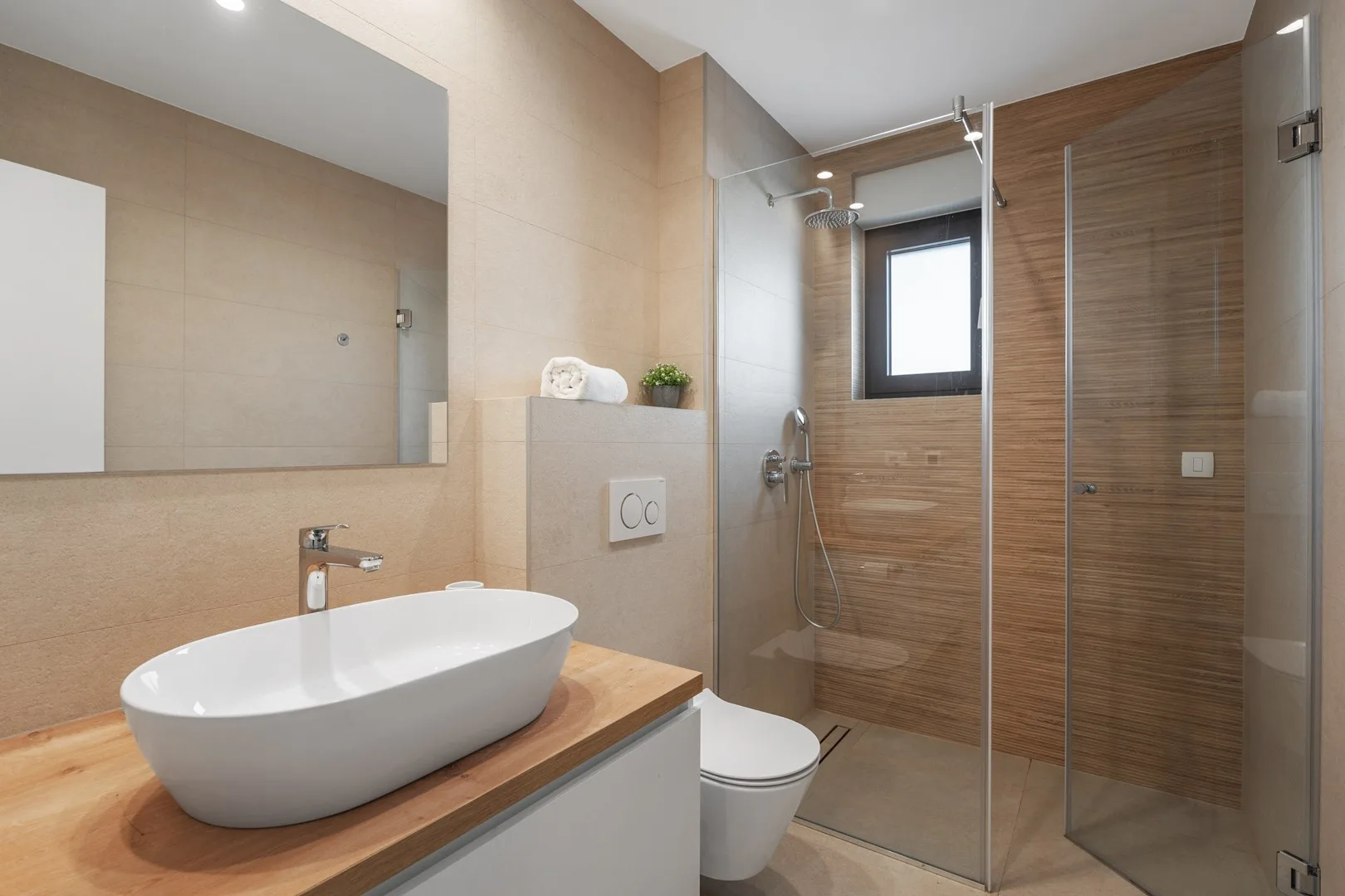 A modern bathroom with a vessel sink and glass-enclosed shower.