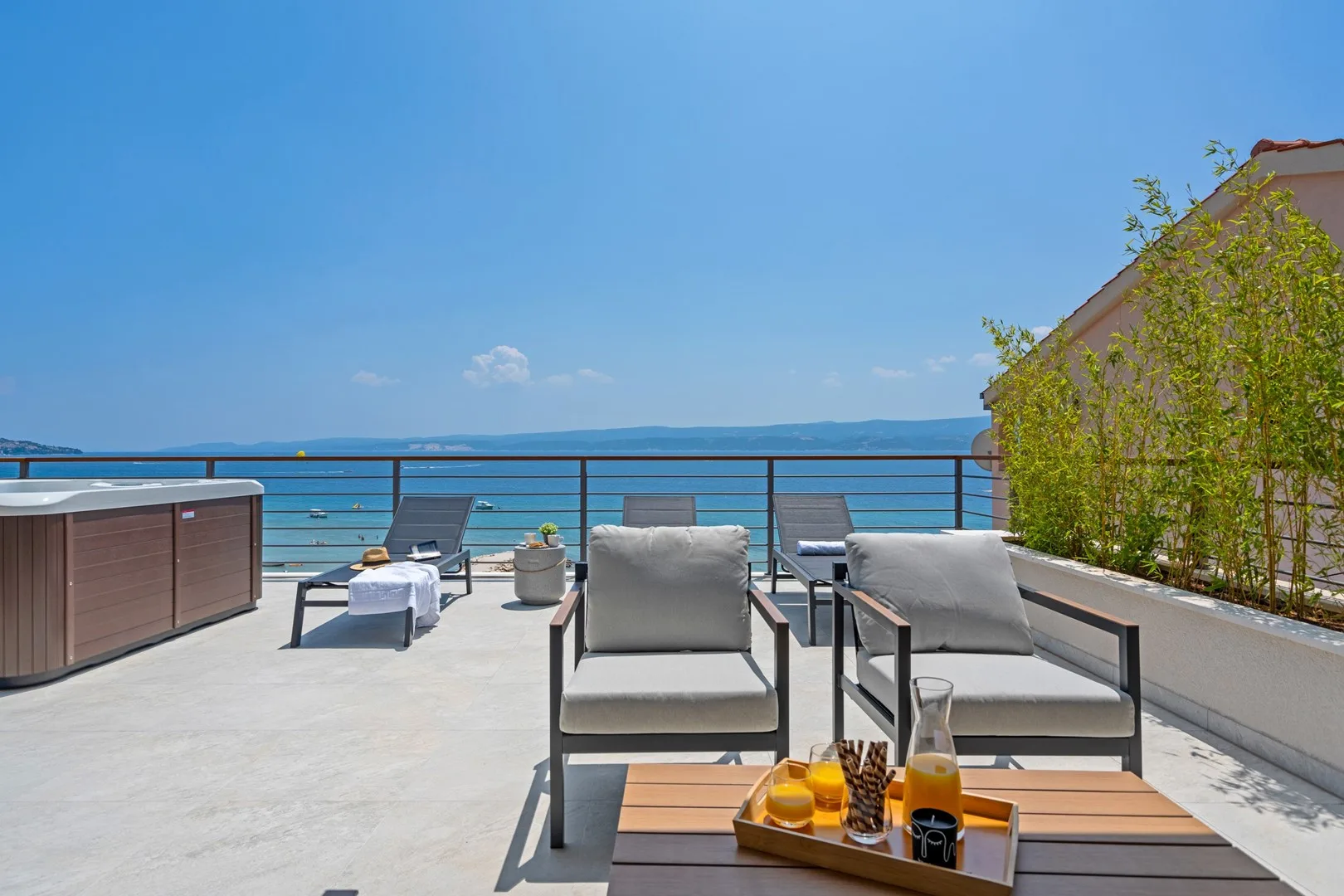 A rooftop terrace with outdoor seating overlooks the sea.