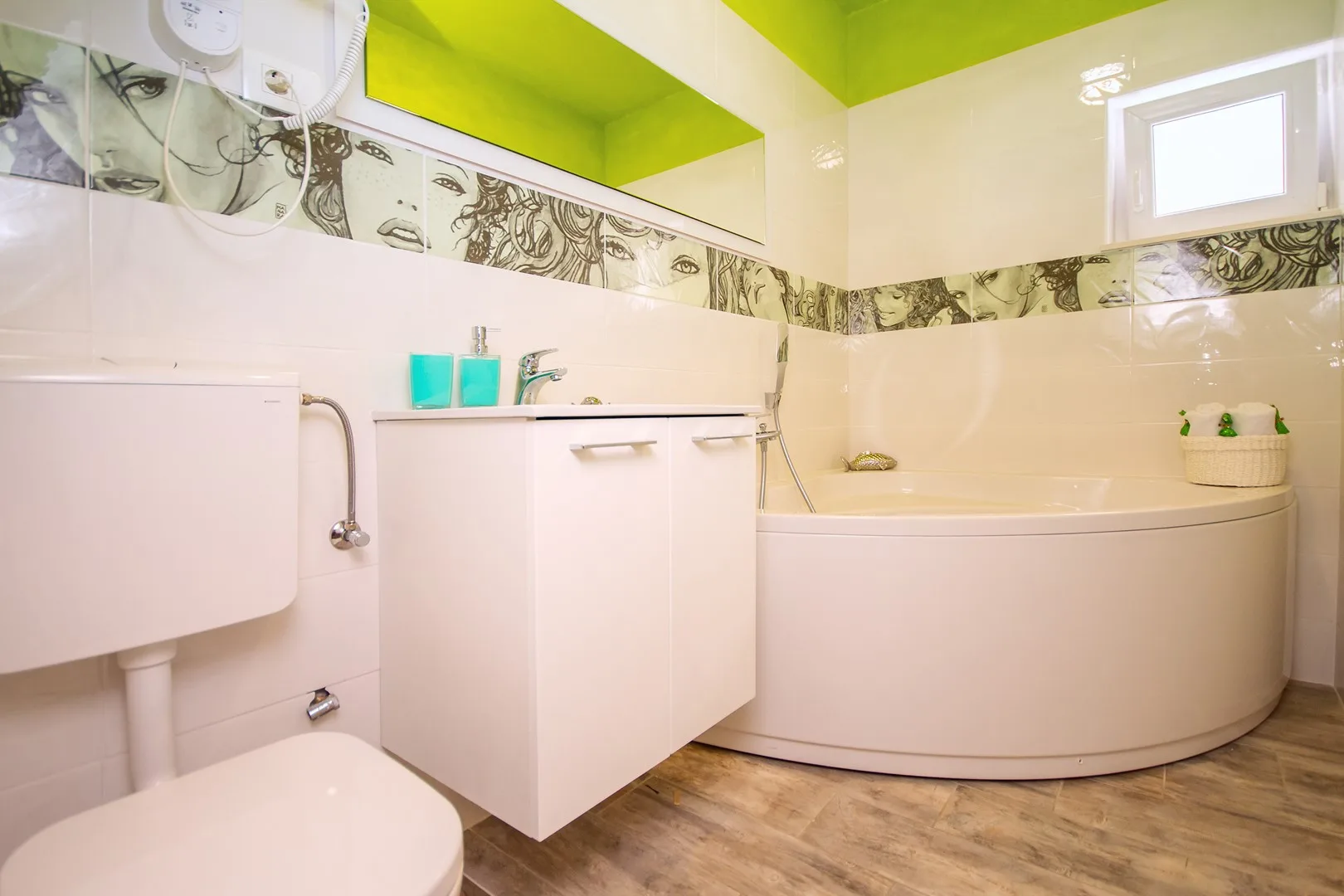 Un baño con bañera, mueble de lavabo e inodoro.