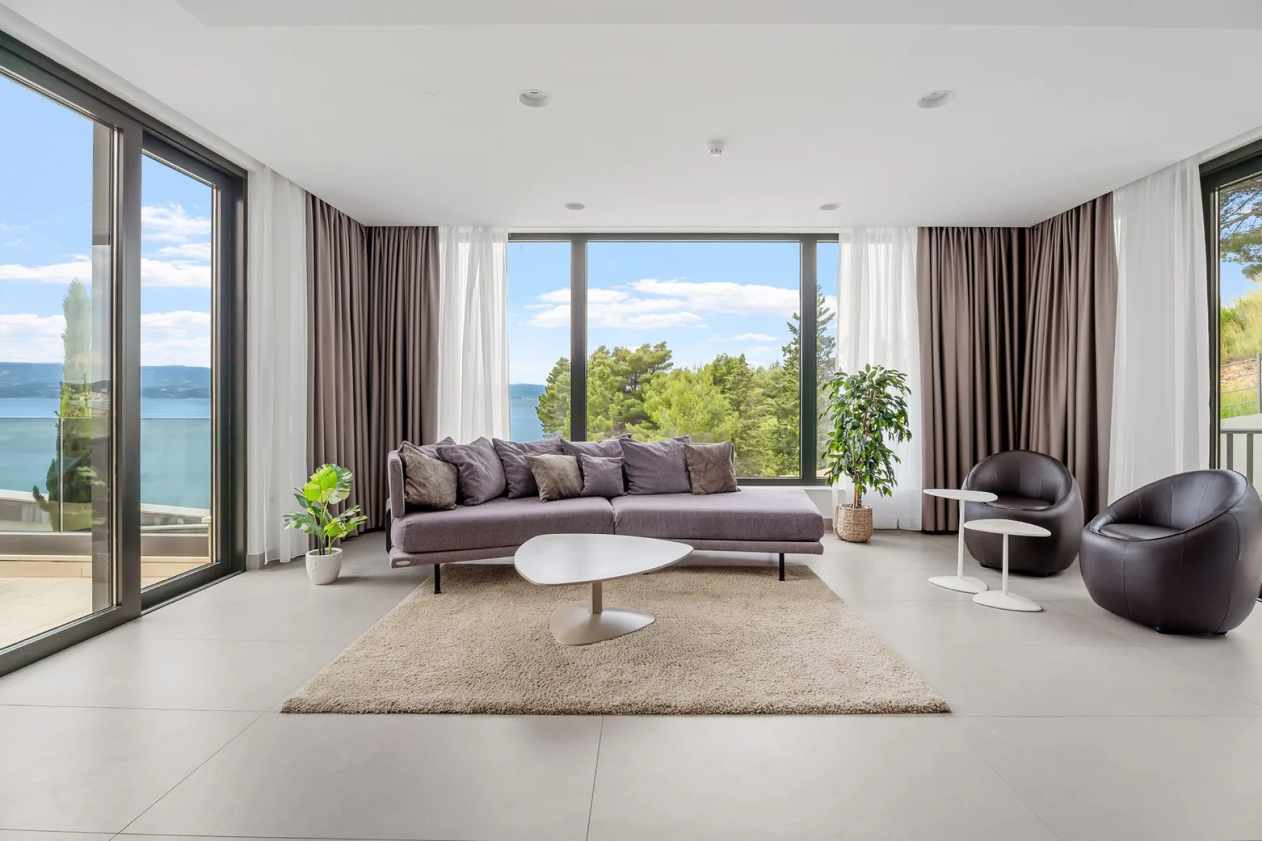 A bright living room with a sofa, coffee table, and large windows.
