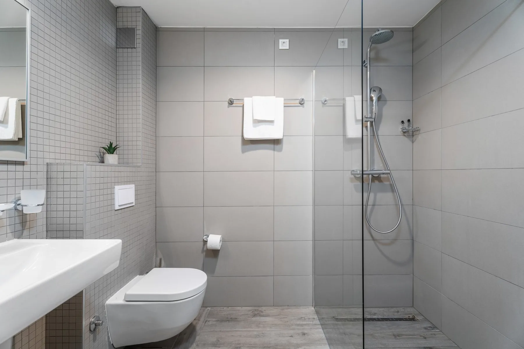 A tiled bathroom with a sink, toilet, and glass shower.