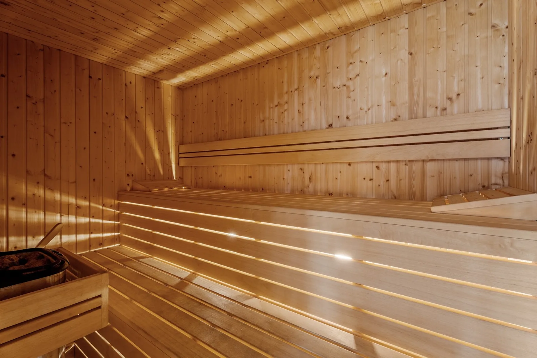 A wood-paneled sauna with tiered wooden seating.