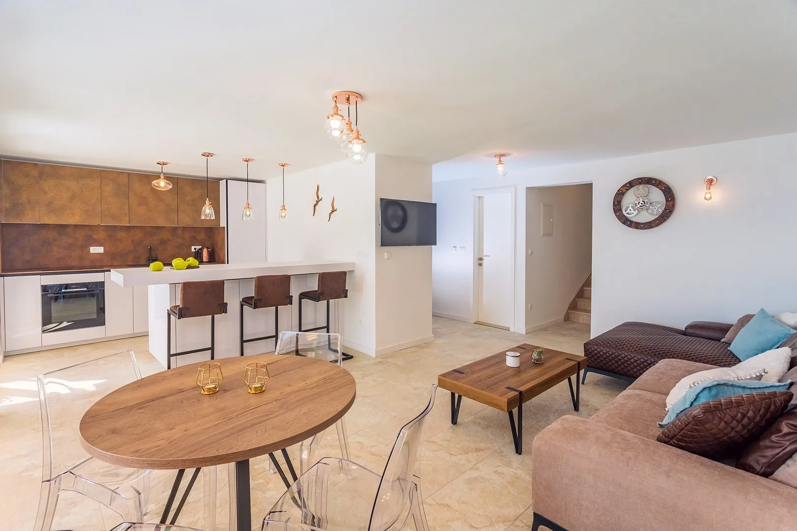 An open-plan living and dining area with a kitchen counter and seating.