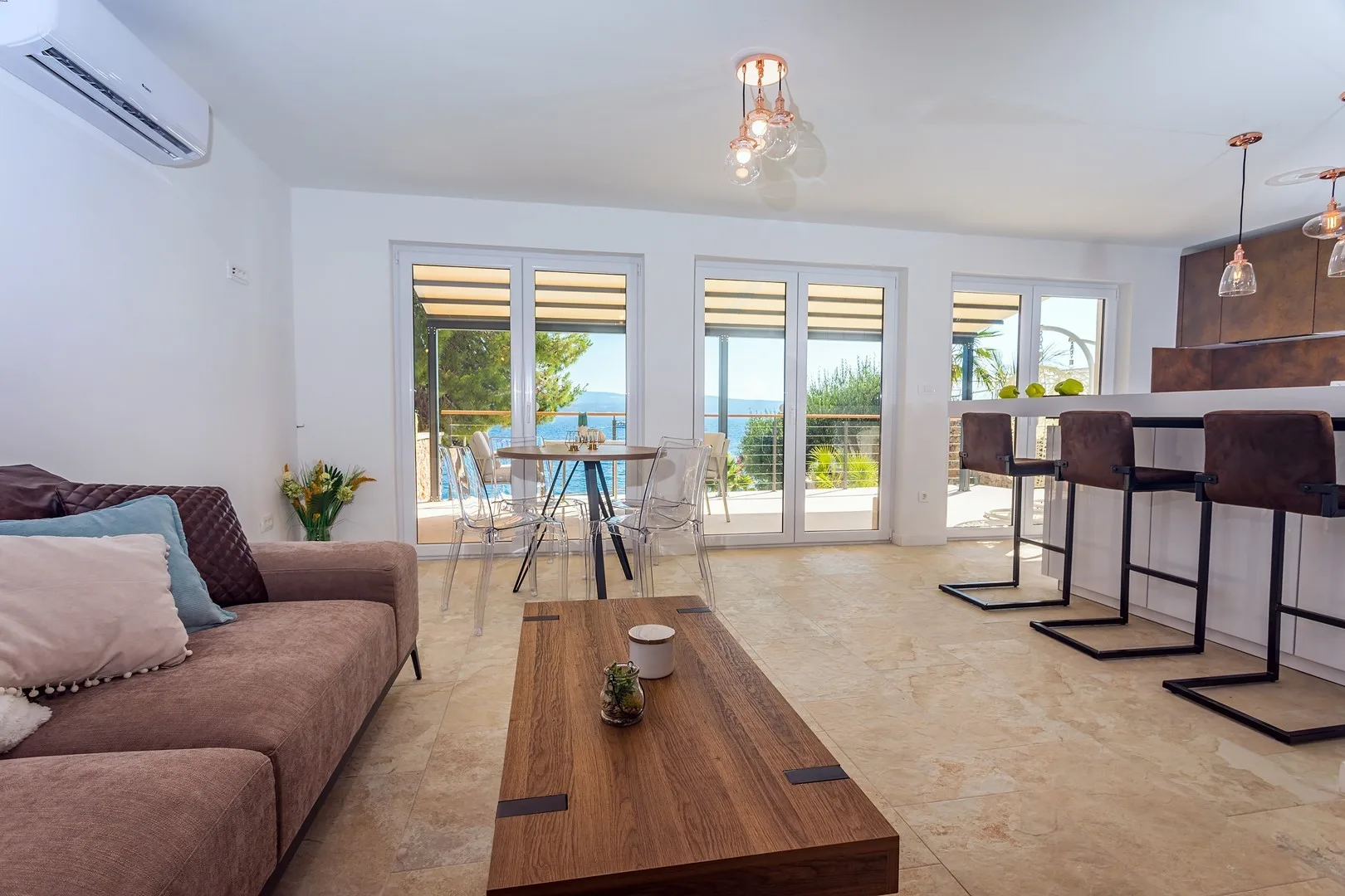 A bright open-plan living and dining area with seating and large glass doors.