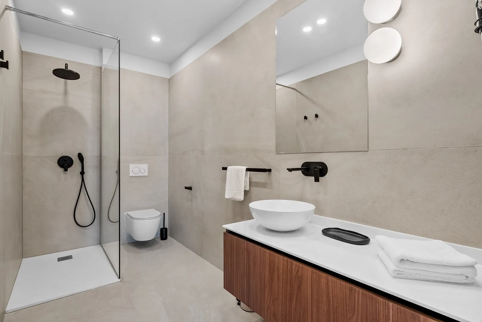 A modern bathroom with a glass-enclosed shower and a vanity sink.