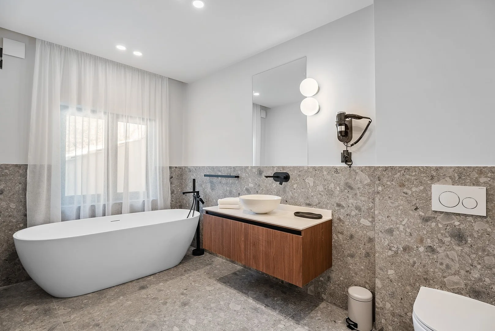 A modern bathroom with a freestanding bathtub and a vanity.